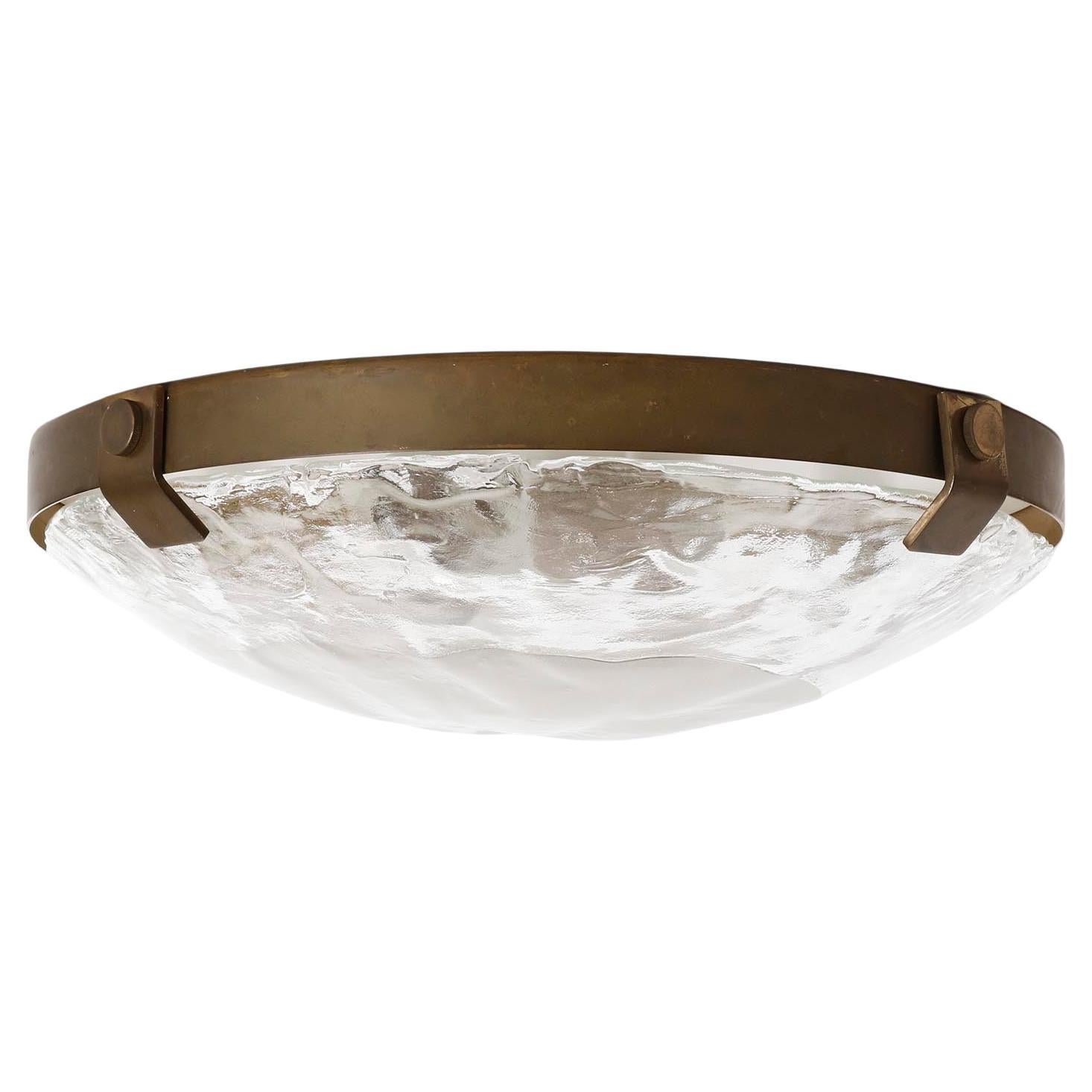 Maravillosa lámpara empotrada de latón patinado y cristal de Murano de J.T. Kalmar, fabricada a mediados de siglo, hacia 1970 (finales de los 60 o principios de los 70).
Se compone de un anillo de latón que sujeta un gran vaso soplado a mano con