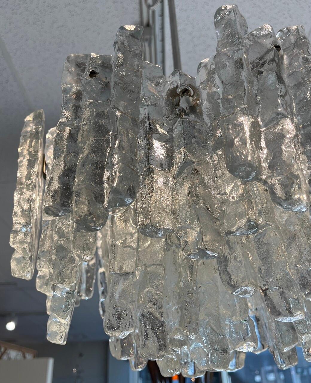 The 1960s Mid-century modern Kalmar Iceicle chandelier embodies the essence of sleek sophistication and timeless elegance. Crafted with meticulous attention to detail, it features a cascade of delicate icicle-like crystals suspended from a