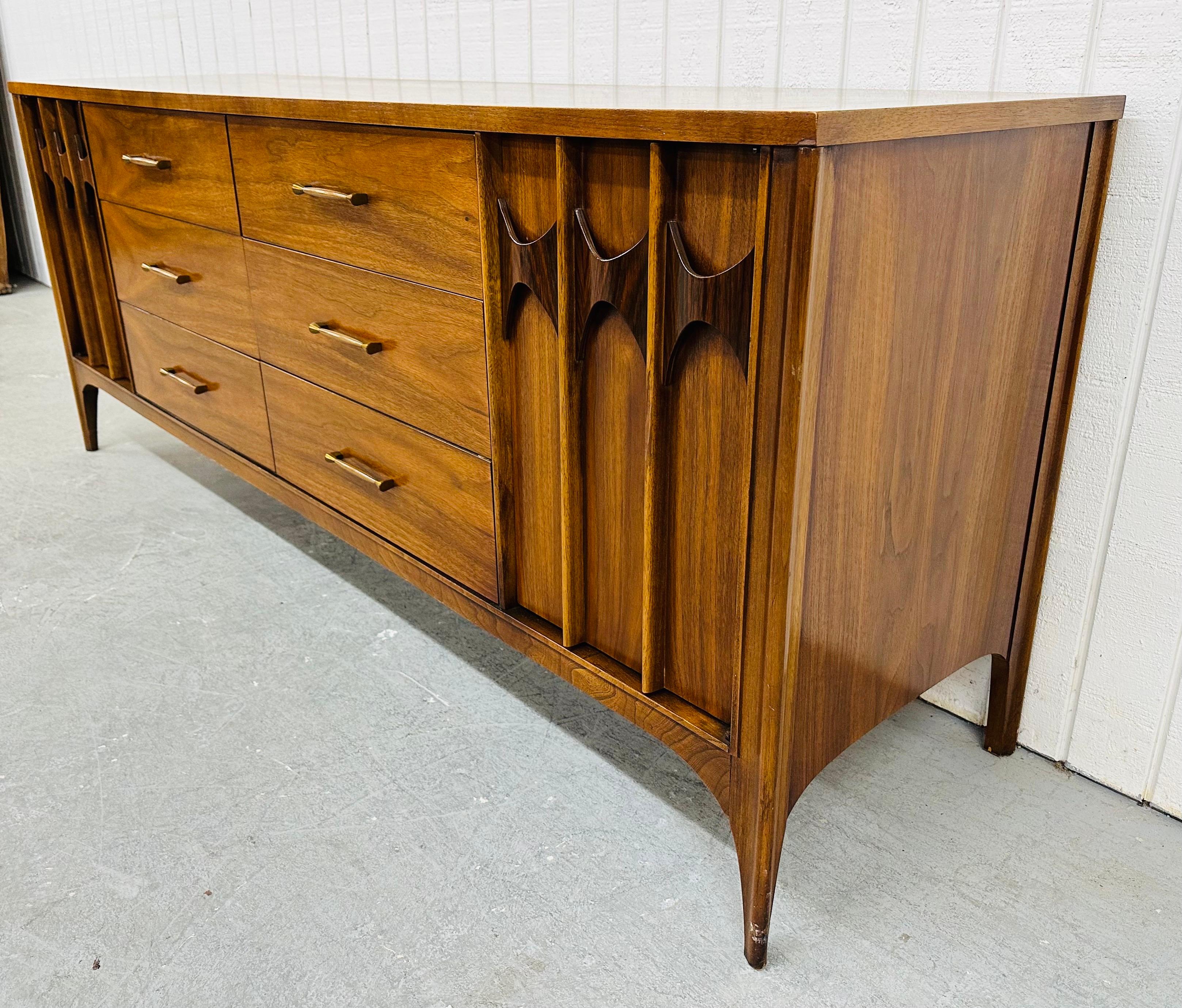 This listing is for a Mid-Century Modern Kent Coffey Perspecta Walnut Dresser. Featuring a straight line design, doors on each side with sculpted rosewood pulls that open up to three hidden drawers, six larger drawers in the center with original