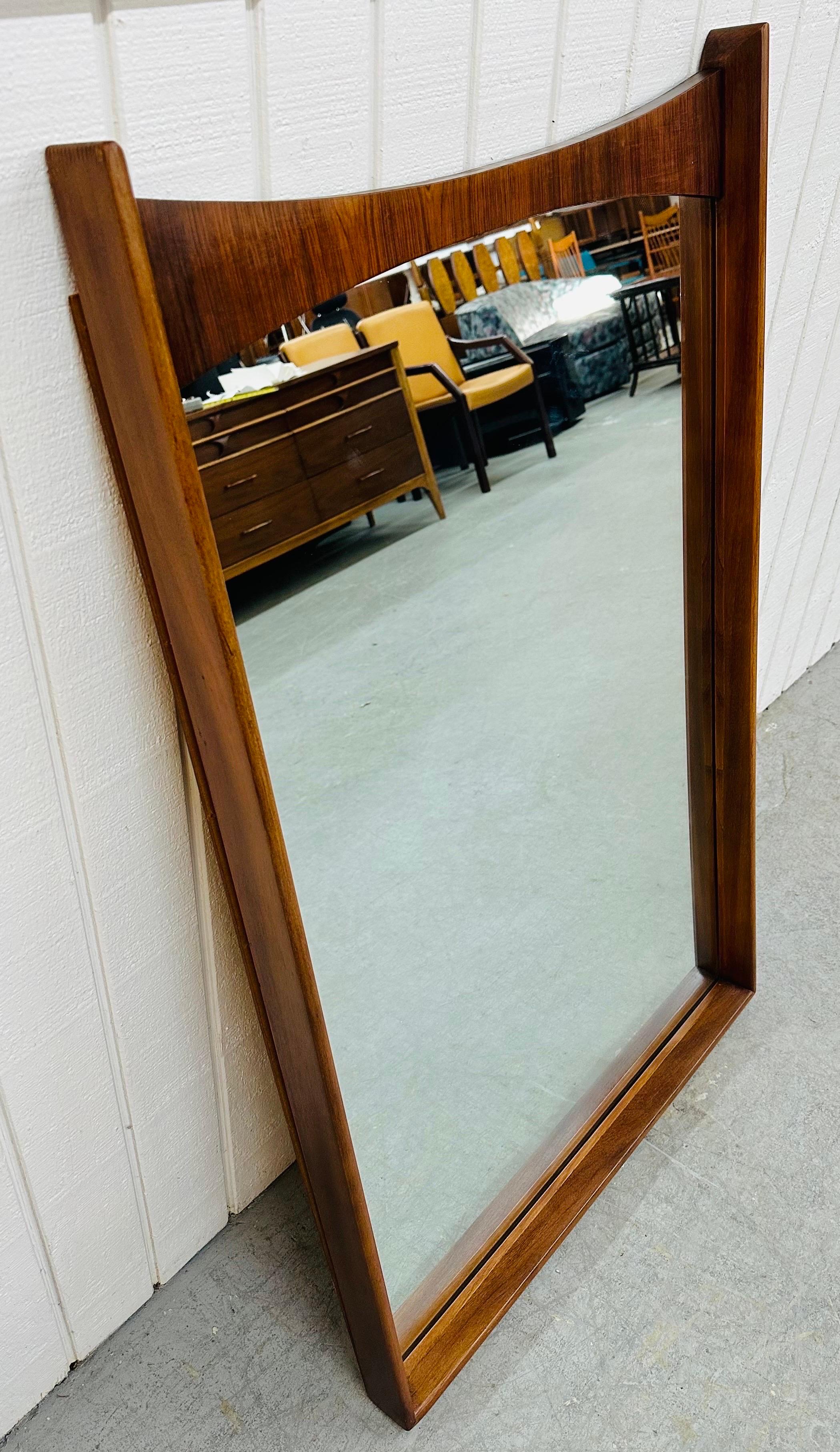 This listing is for a Mid-Century Modern Kent Coffey Perspecta Wall Mirror. Featuring a straight line rectangular design with curved top, solid wood frame, beveled mirror, and rosewood accent at the top. This is an exceptional combination of quality