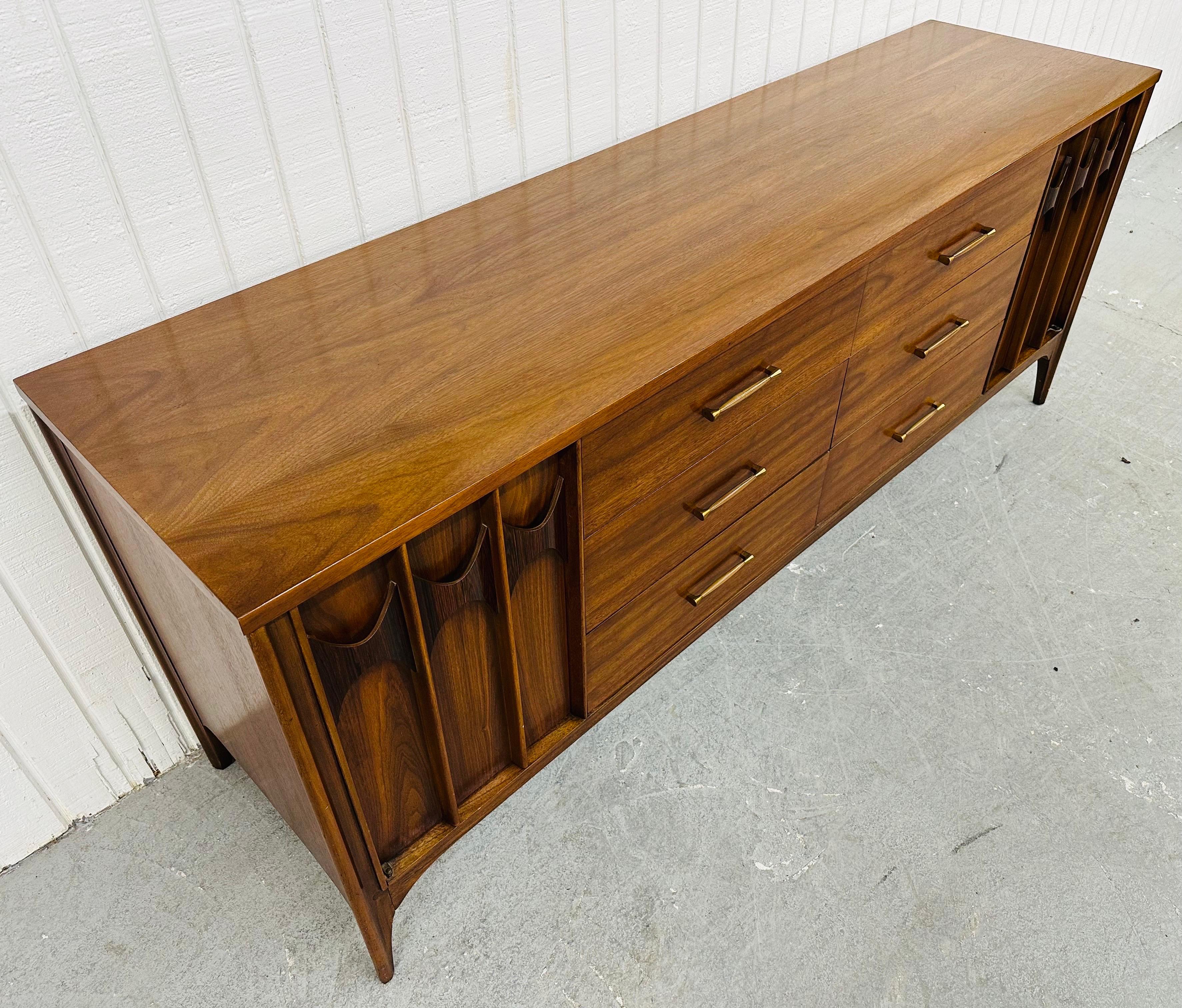 This listing is for a Mid-Century Modern Kent Coffey Perspecta Walnut 12-Drawer Dresser. Featuring a straight line design, two doors with sculpted rosewood pulls that open up to three hidden drawers, six larger center drawers with original hardware,