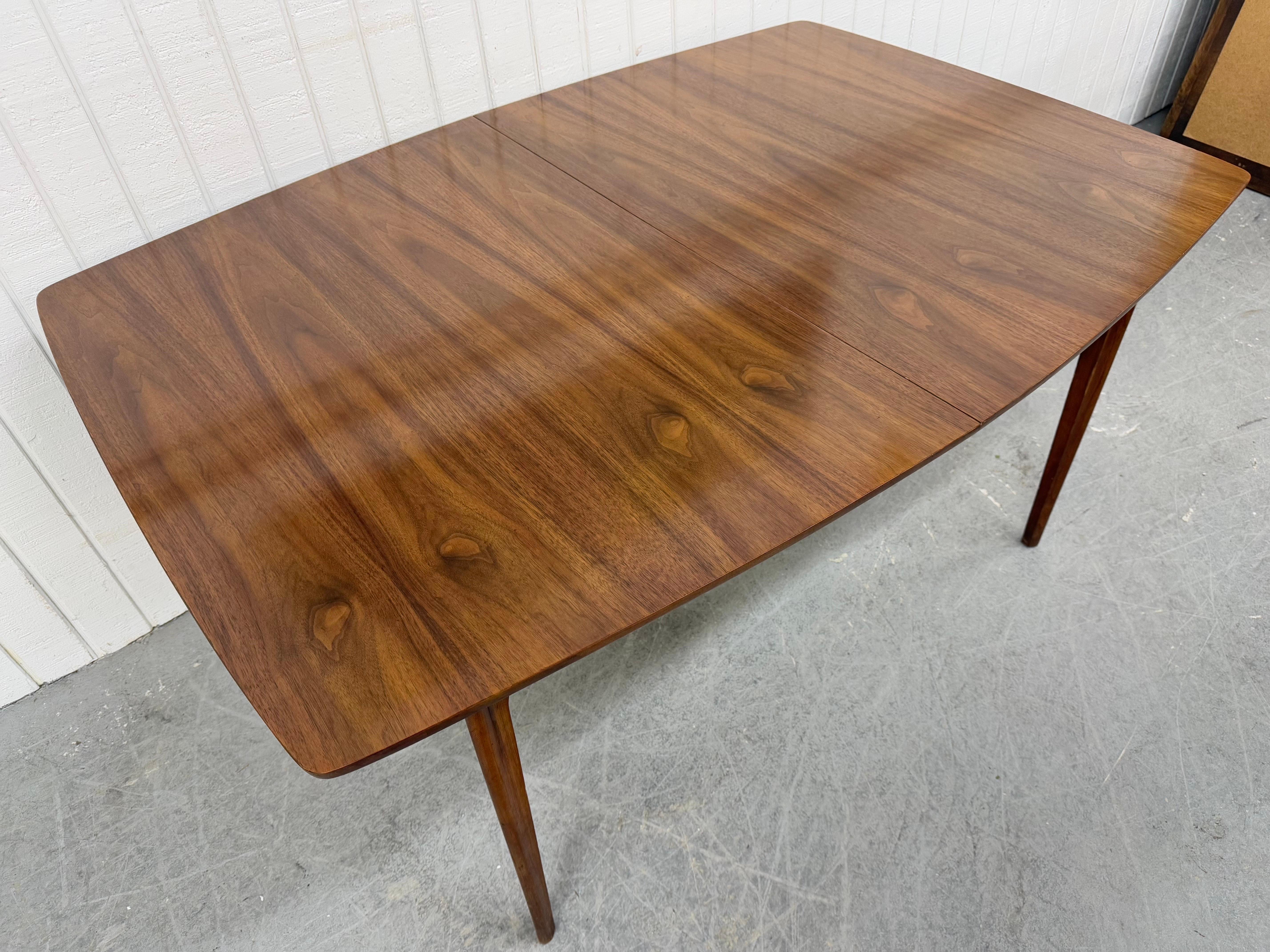 This listing is for a Mid-Century Modern Kent Coffey Perspecta Walnut Dining Table. Featuring a rectangular top, four removable pinched legs, one leaf to expand the length to 71.75” L, and a beautiful walnut finish. This is an exceptional