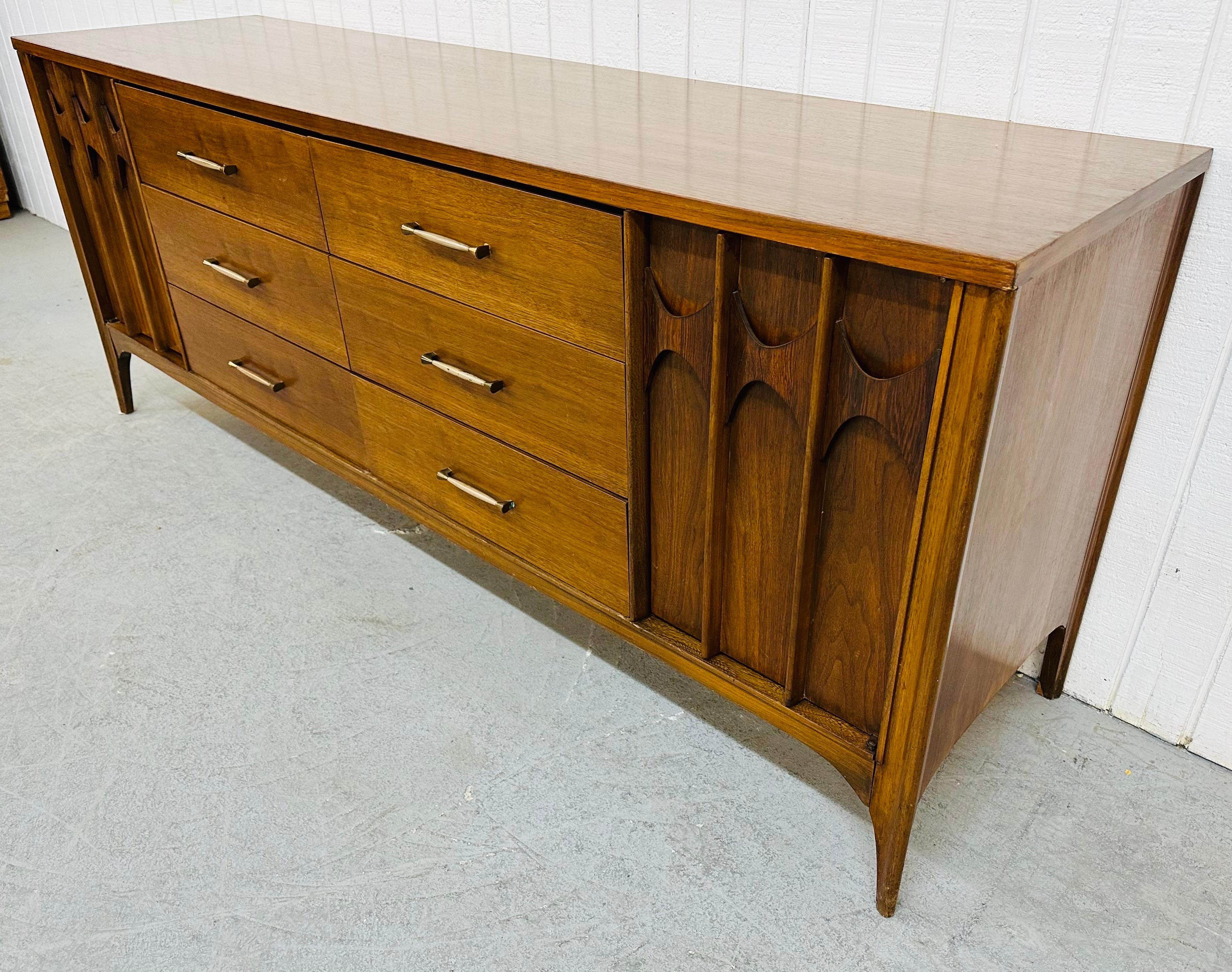 This listing is for a Mid-Century Modern Kent Coffey Perspecta Walnut 12-Drawer Dresser. Featuring doors on each side with sculpted rosewood pulls that open up to three hidden drawers, six larger drawers in the center with original hardware, and a