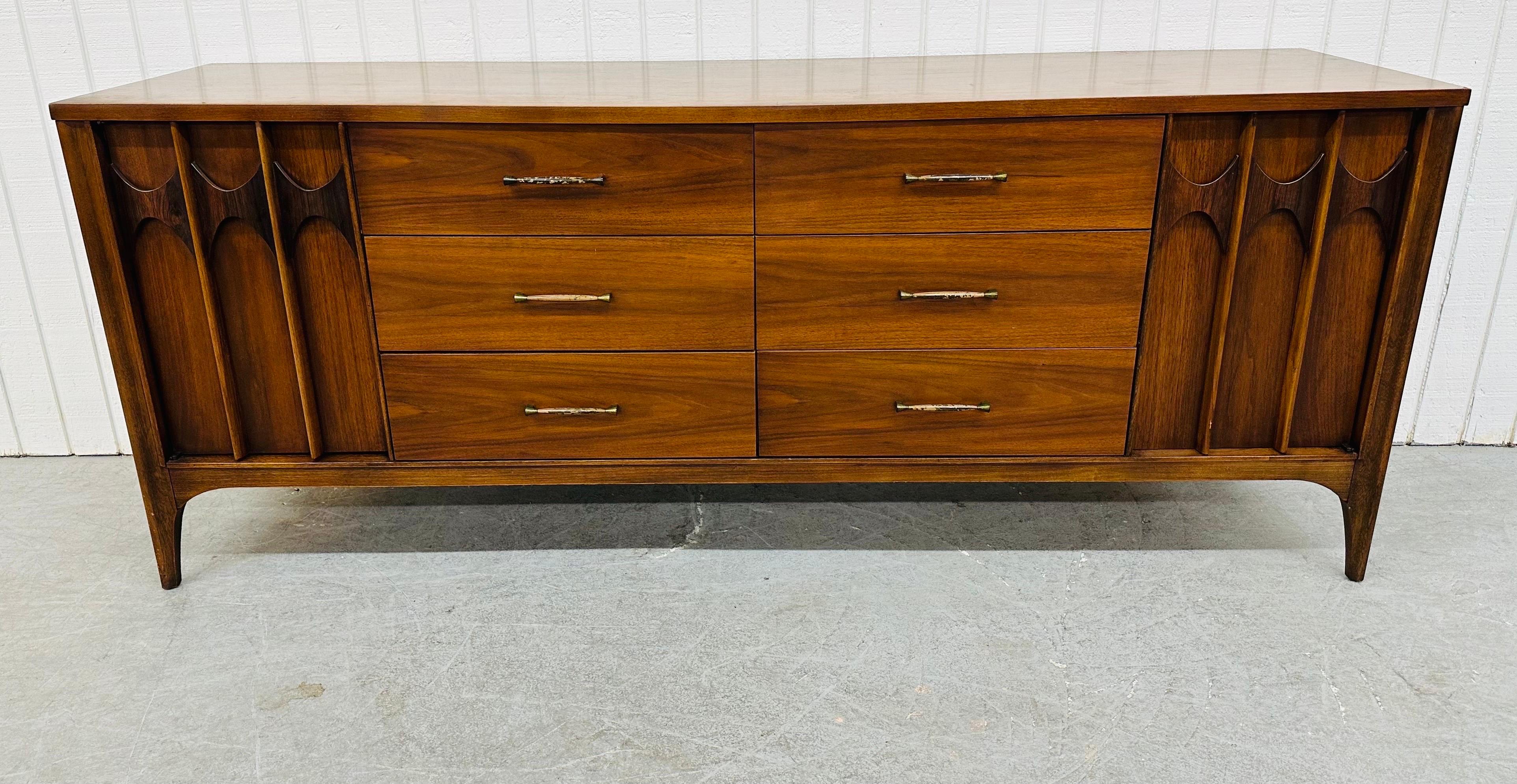 This listing is for a Mid-Century Modern Kent Coffey Perspecta Walnut Dresser. Featuring a straight line design, two doors with sculpted rosewood pulls that open up to three hidden drawers, six larger center drawers, original hardware, and a