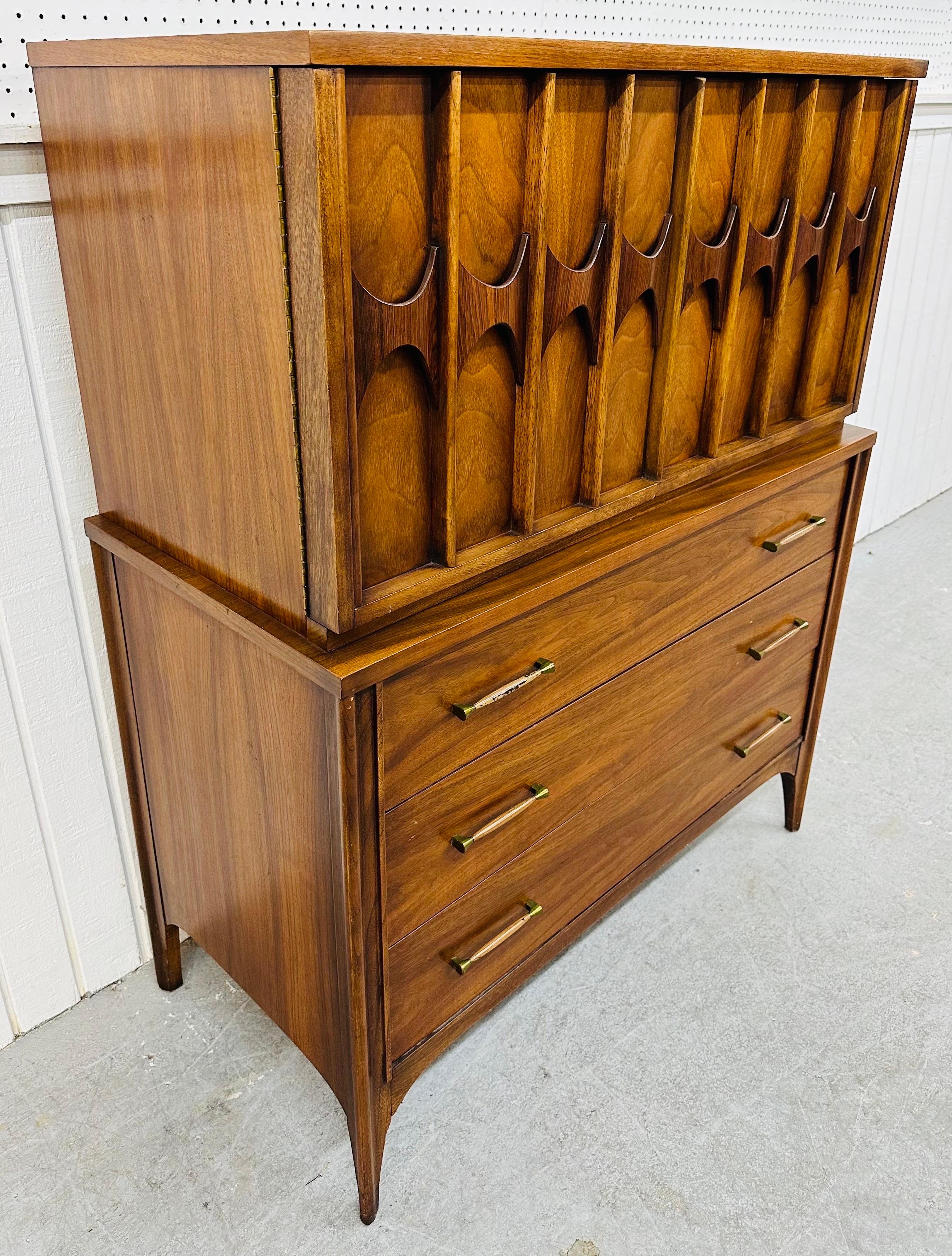 This listing is for a Mid-Century Modern Kent Coffey Perspecta Walnut Gentlemen’s Chest. Featuring a straight line design, two doors with sculpted rosewood pulls that open up to two hidden drawers and storage space. The bottom half of the chest has