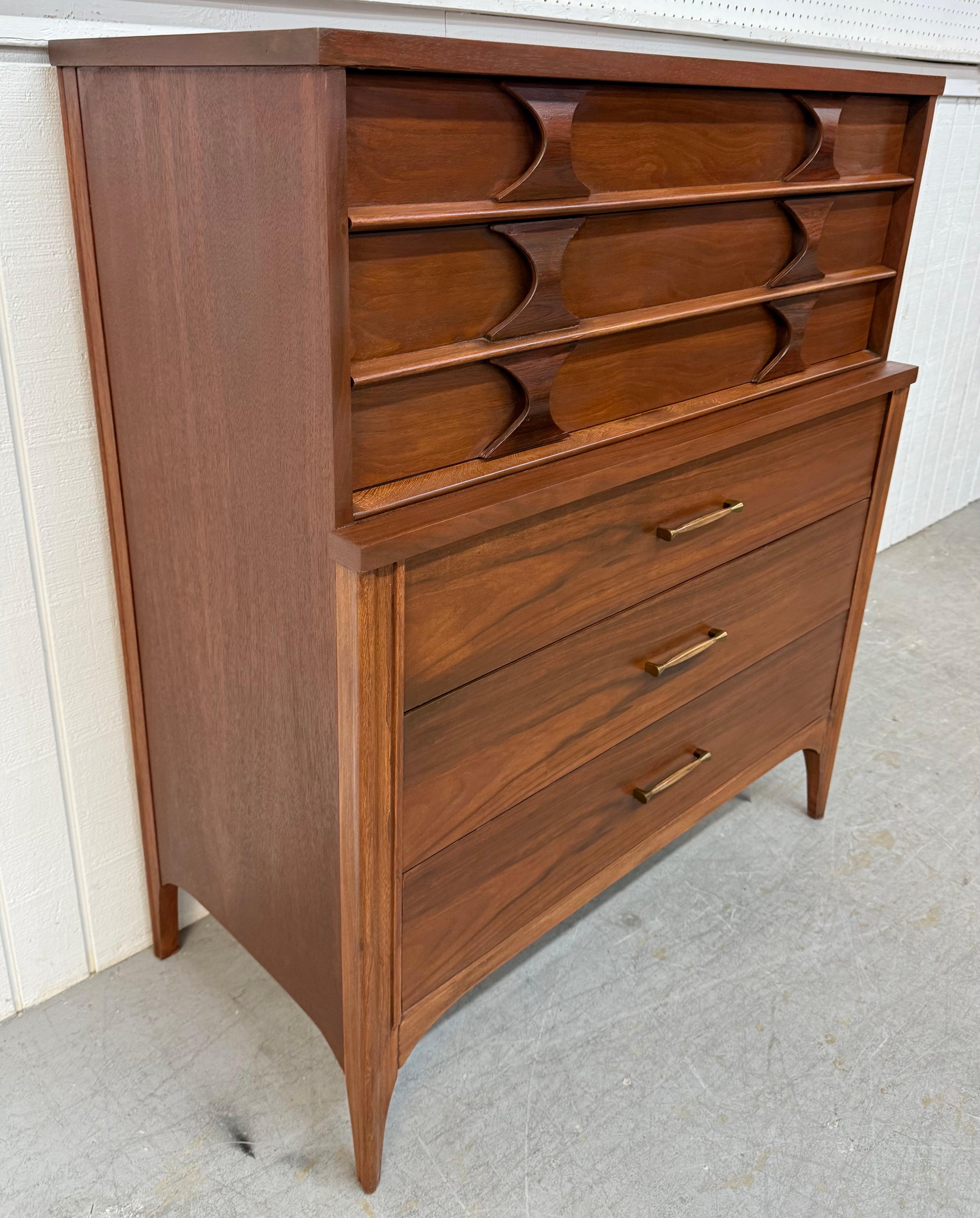 This listing is for a Mid-Century Modern Kent Coffey Perspecta Walnut High Chest. Featuring a straight line design, five drawers for storage, sculpted rosewood pulls, original hardware, modern legs, and a beautiful walnut finish. This is an