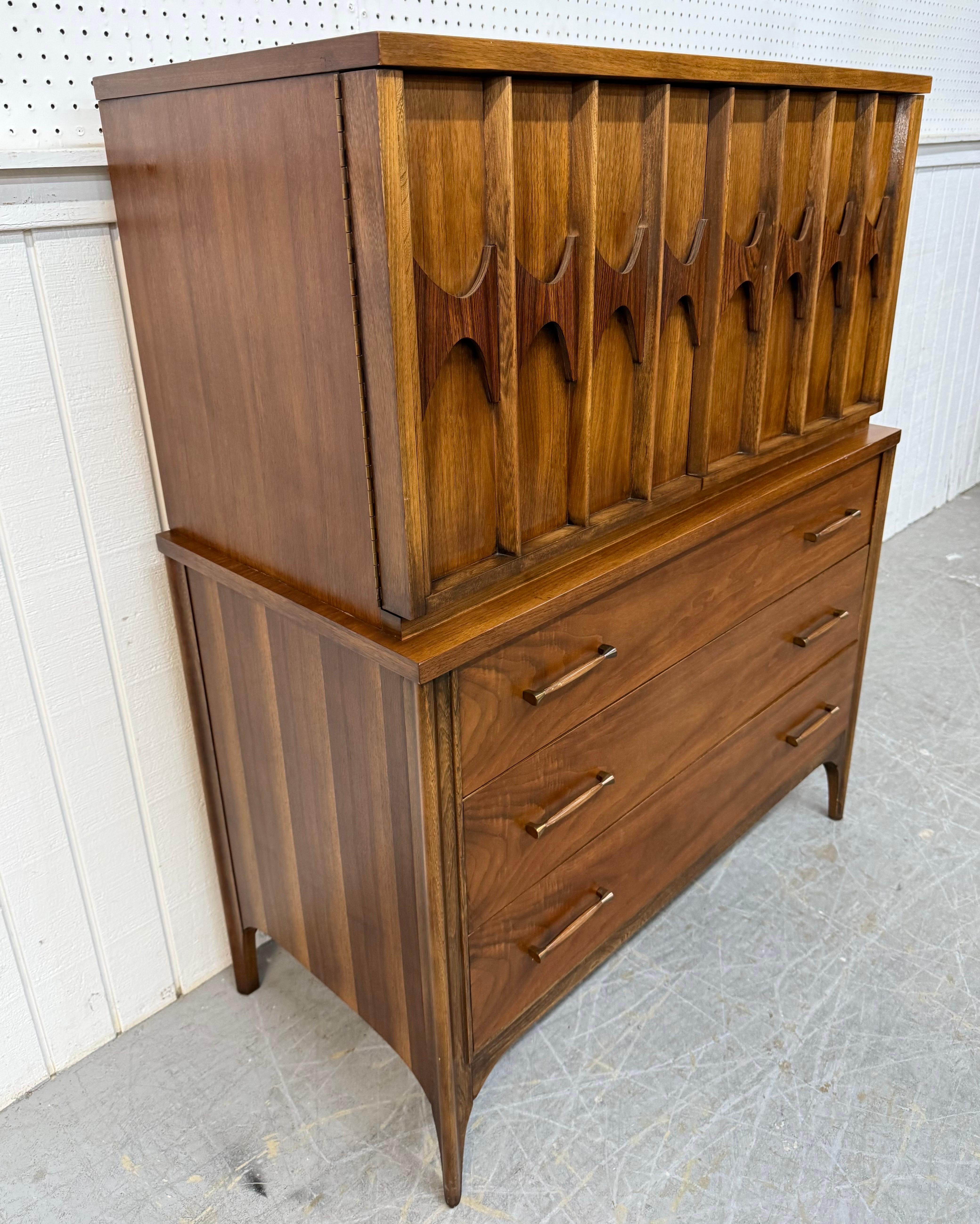 This listing is for a Mid-Century Modern Kent Coffey Perspecta Walnut High Chest. Featuring a straight line chest-on-chest design, two large doors at the top with sculpted rosewood pulls that open up to storage space, three drawers at the bottom