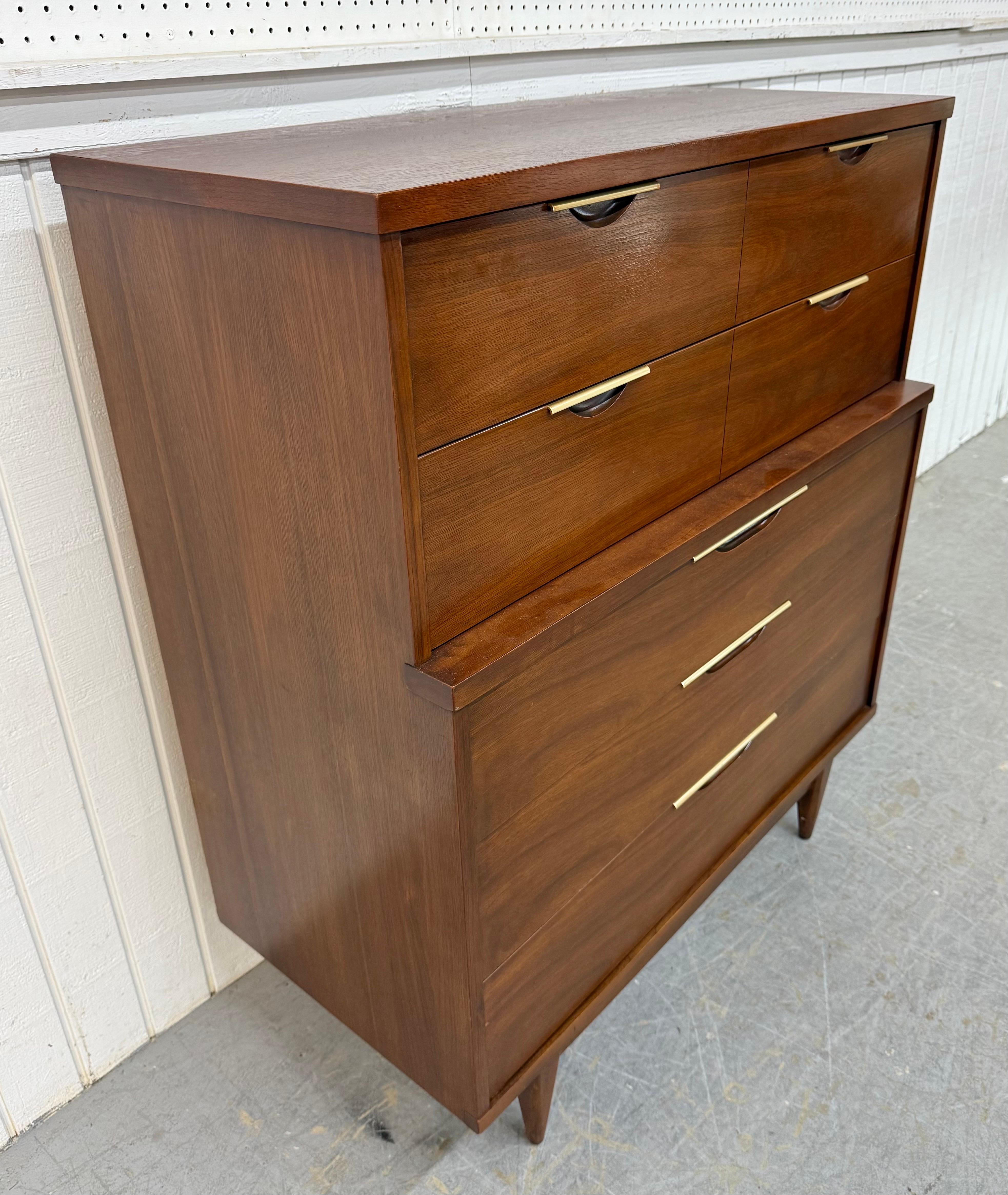 This listing is for a Mid-Century Modern Kent Coffey Tableau Walnut High Chest. Featuring a straight line design, five drawers with brass hardware, modern legs, and a beautiful walnut finish. This is an exceptional combination of quality and MCM