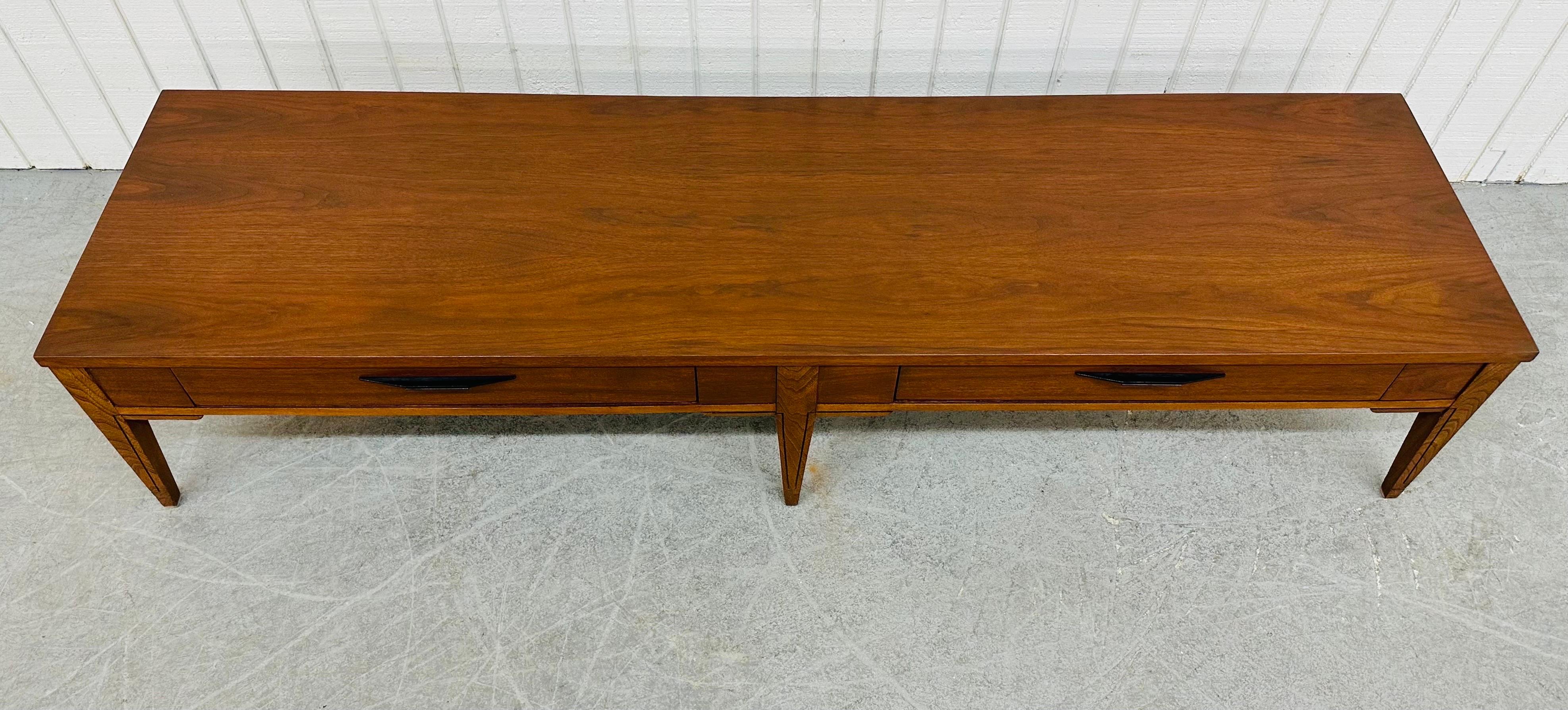 This listing is for a Mid-Century Modern Kent Coffey Tempo Walnut Coffee Table. Featuring a straight line design, long rectangular top, two drawers with original black metal hardware, modern legs, and a beautiful walnut finish. This is an