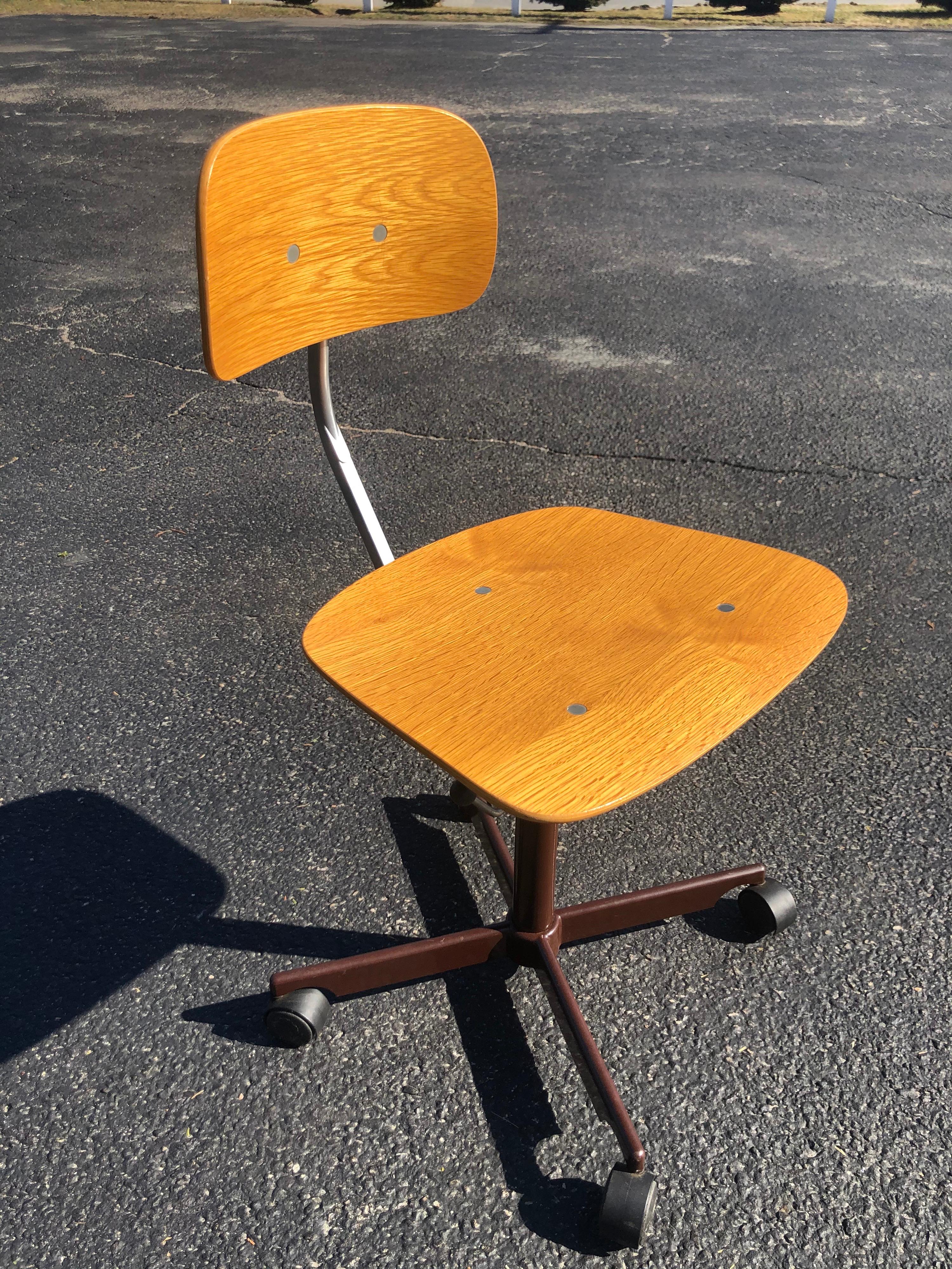 Mid-Century Modern Kevi task desk chair by Jørgen Rasmussen for Rabami Stole. Bent plywood office chair with painted brown X base and castor wheels. Seat height and upper tilt back are adjustable.
Stamped KEVI on underside. Made in Denmark. This