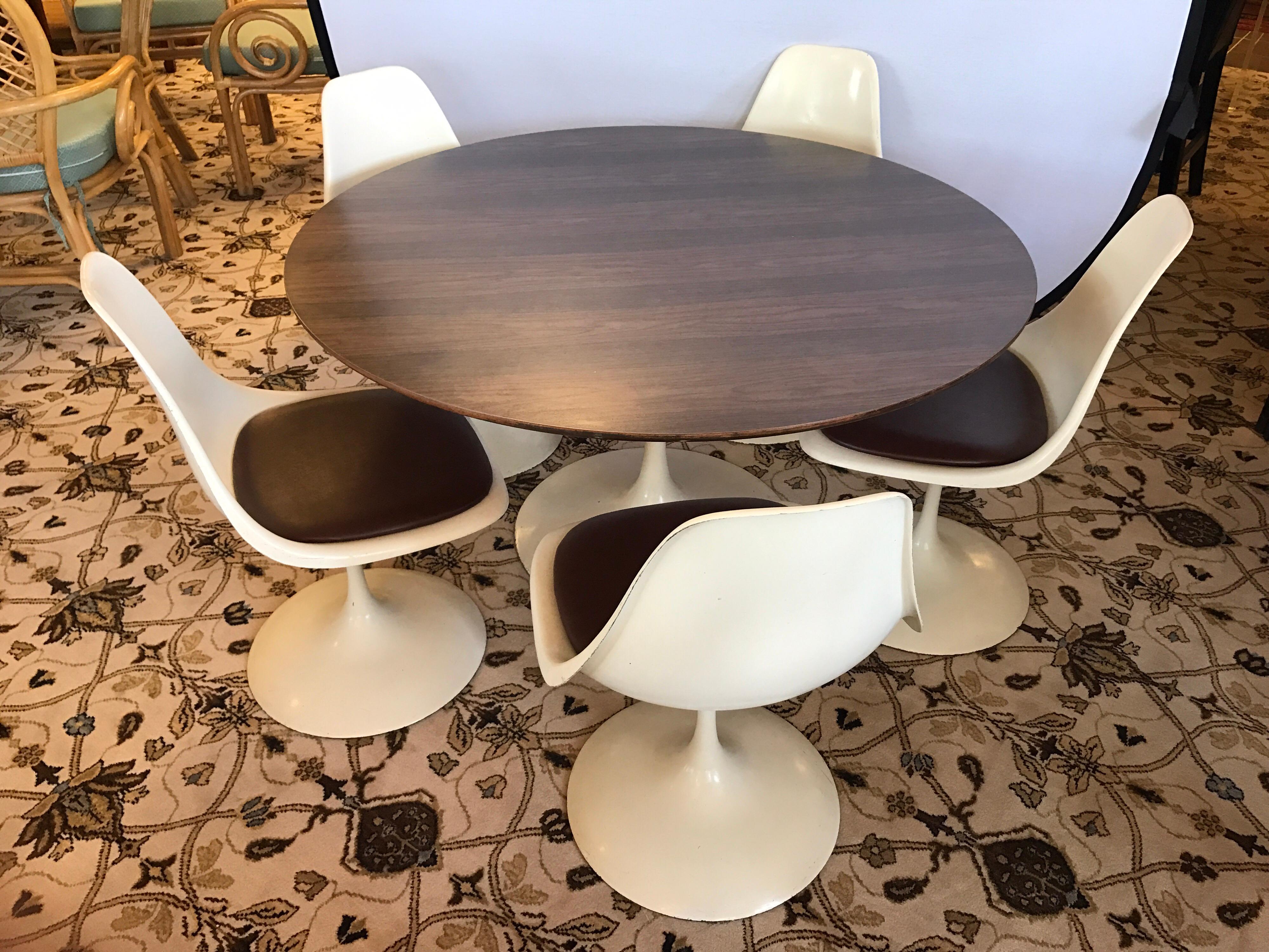 Vintage midcentury child size tulip table with metal base and wood laminate top for easy clean-up. The five matching tulip chairs are also child size and swivel 360 degrees and brown vinyl seat cushions. 
Table dimensions are below and chair