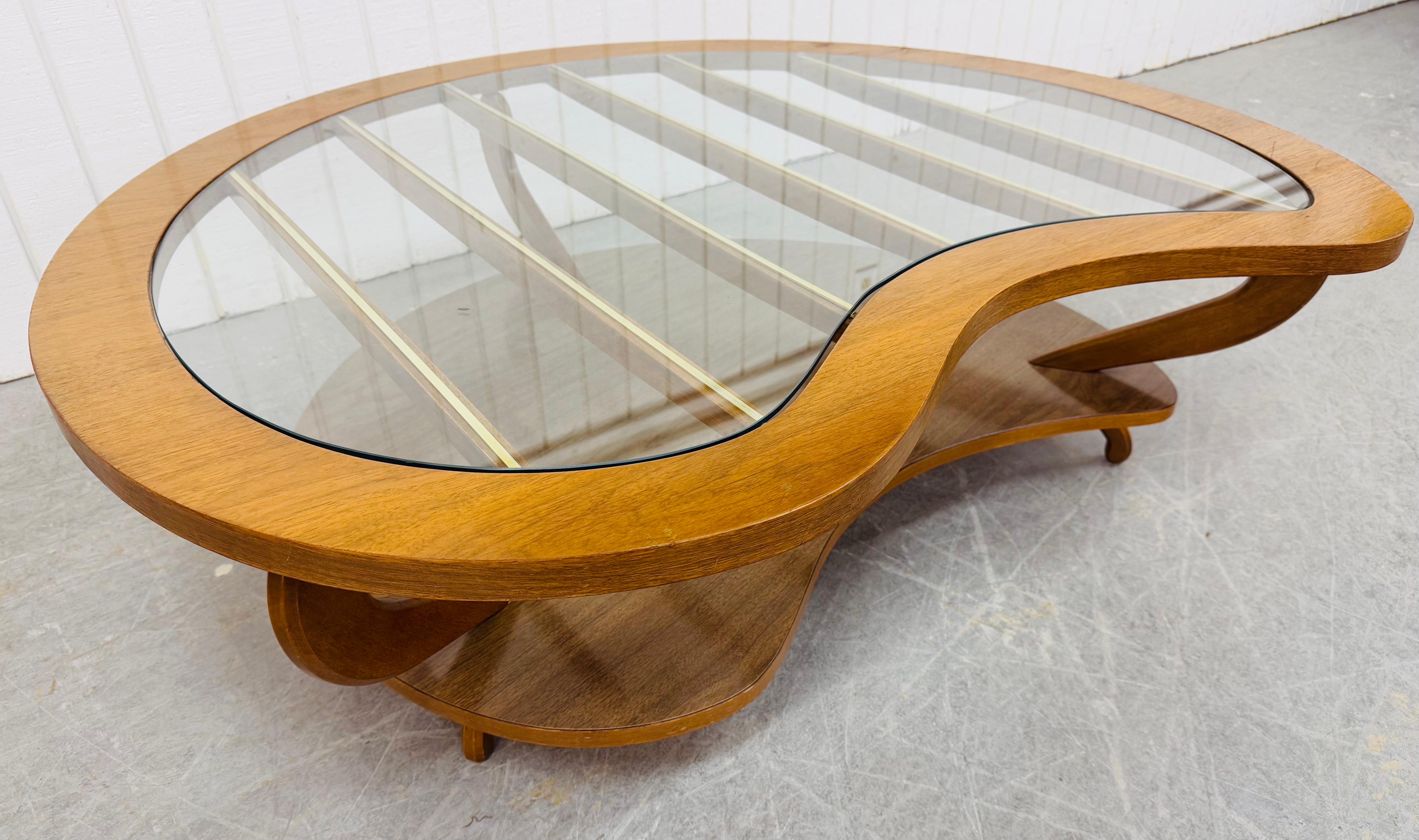 This listing is for a Mid-Century Modern Kidney Glass Top Walnut Coffee Table. Featuring a kidney glass top design, bottom laminated magazine storage area, sculpted legs, and a beautiful walnut finish. This is an exceptional combination of quality