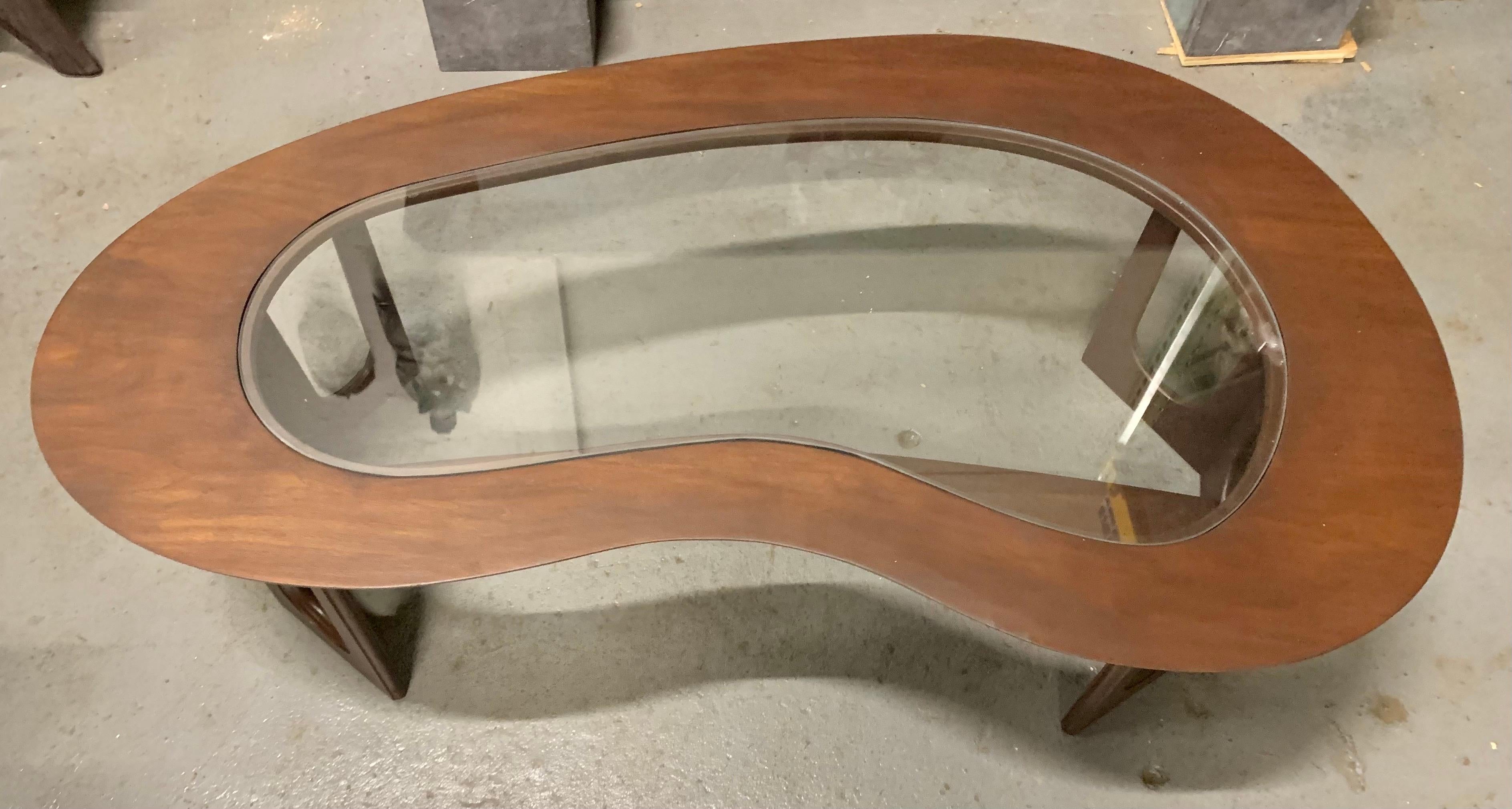 Curved midcentury kidney shaped cocktail table with glass insert top surrounded by walnut wood.
Now, more than ever, home is where the heart is.
