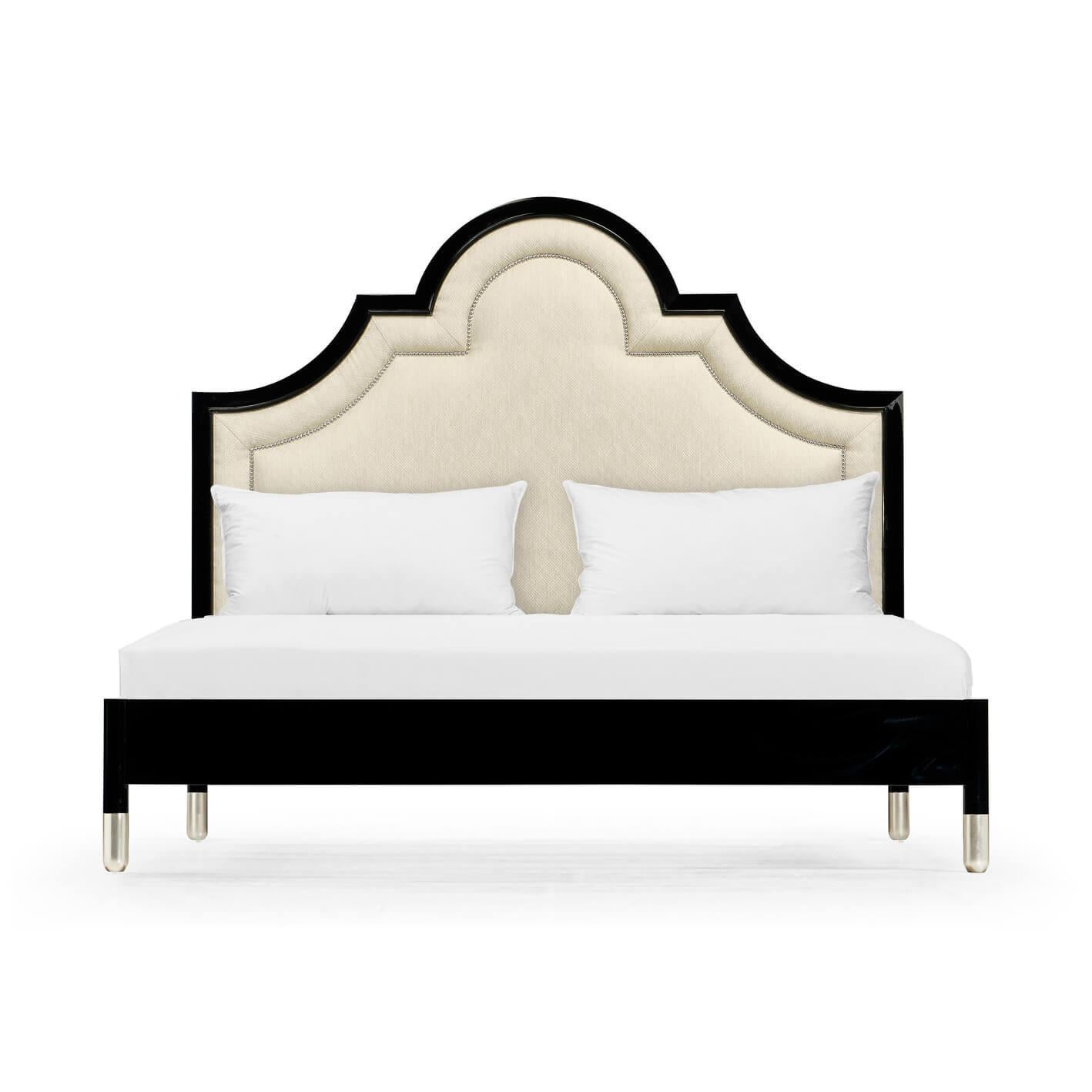 A Mid-Century Modern style black lacquered king size bed. The piano black polished finish to the arched and upholstered headboard with nickel-plated nailhead trim, above a lacquered frame.

Dimensions: 81.5