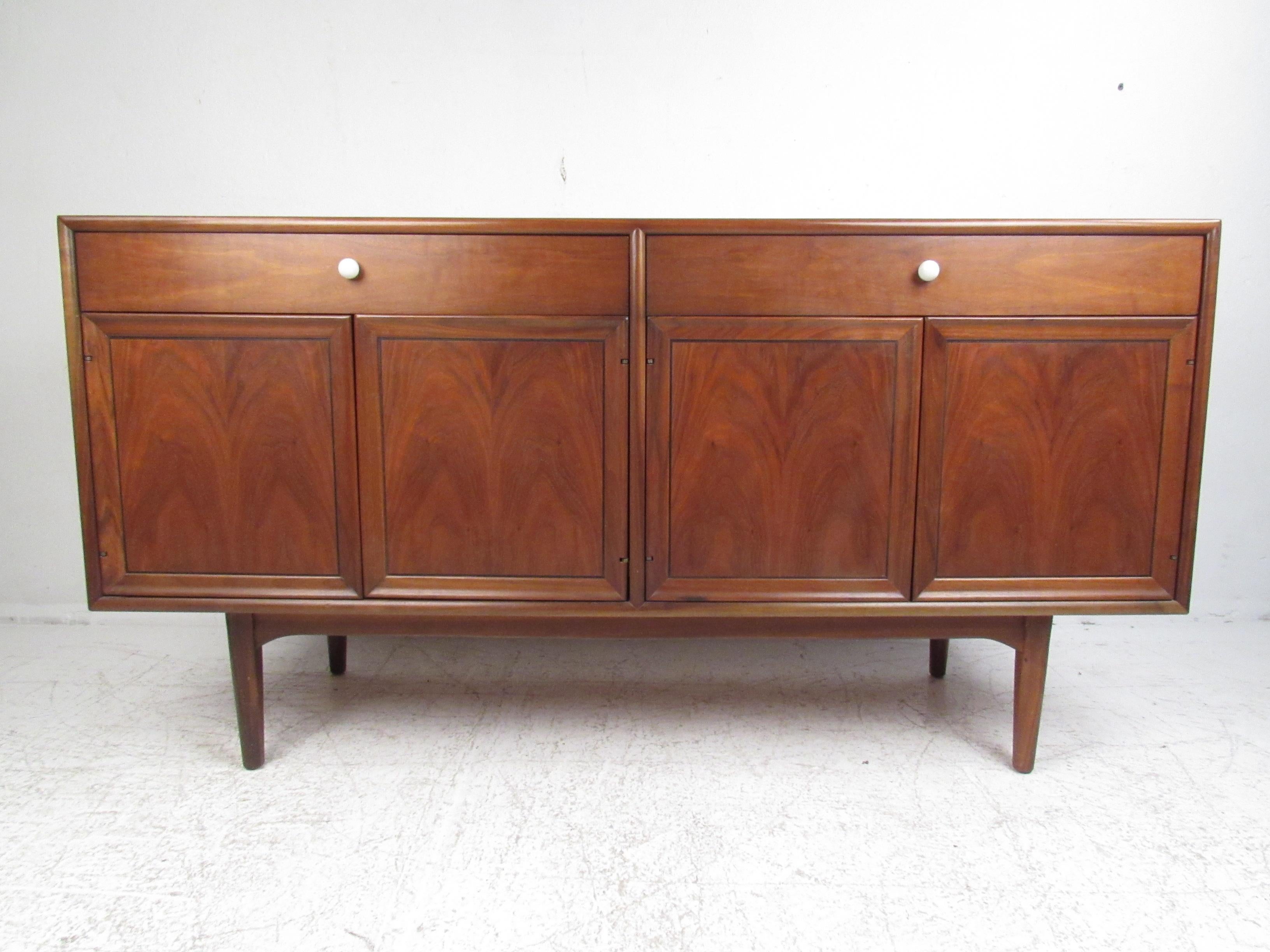 A stunning vintage modern Drexel Declaration buffet Credenza by Kipp Stewart and Stewart McDougall. This stylish case piece features book-matched black walnut wood grains highlighted by their iconic white porcelain pulls. The versatile design is