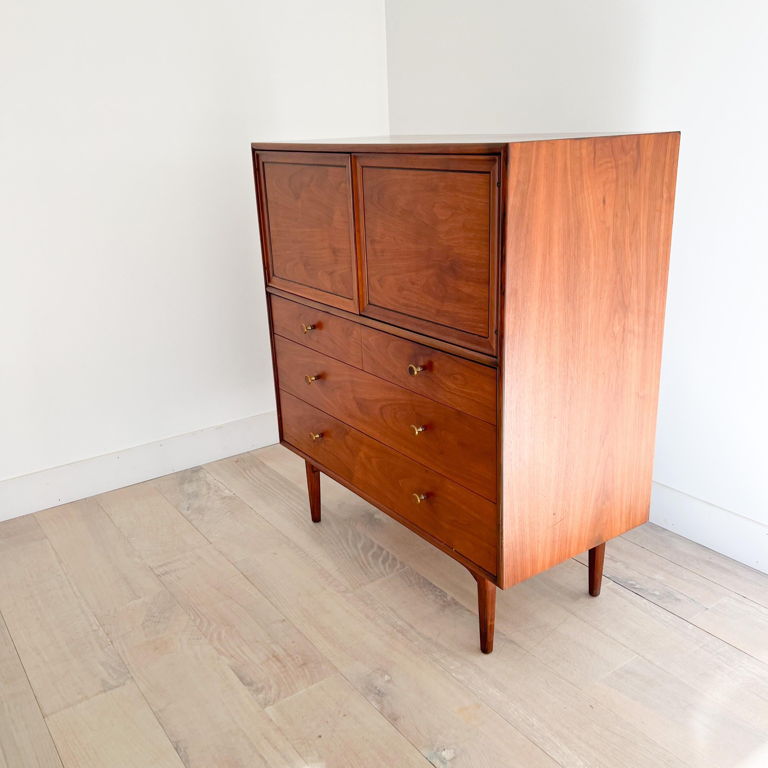 Mid century modern walnut dresser designed by Kipp Stewart for the Drexel Declaration line. Some light wear/scuffing from age appropriate wear. The right cabinet door opens nicely with a push to the top left corner. The left cabinet door can then be