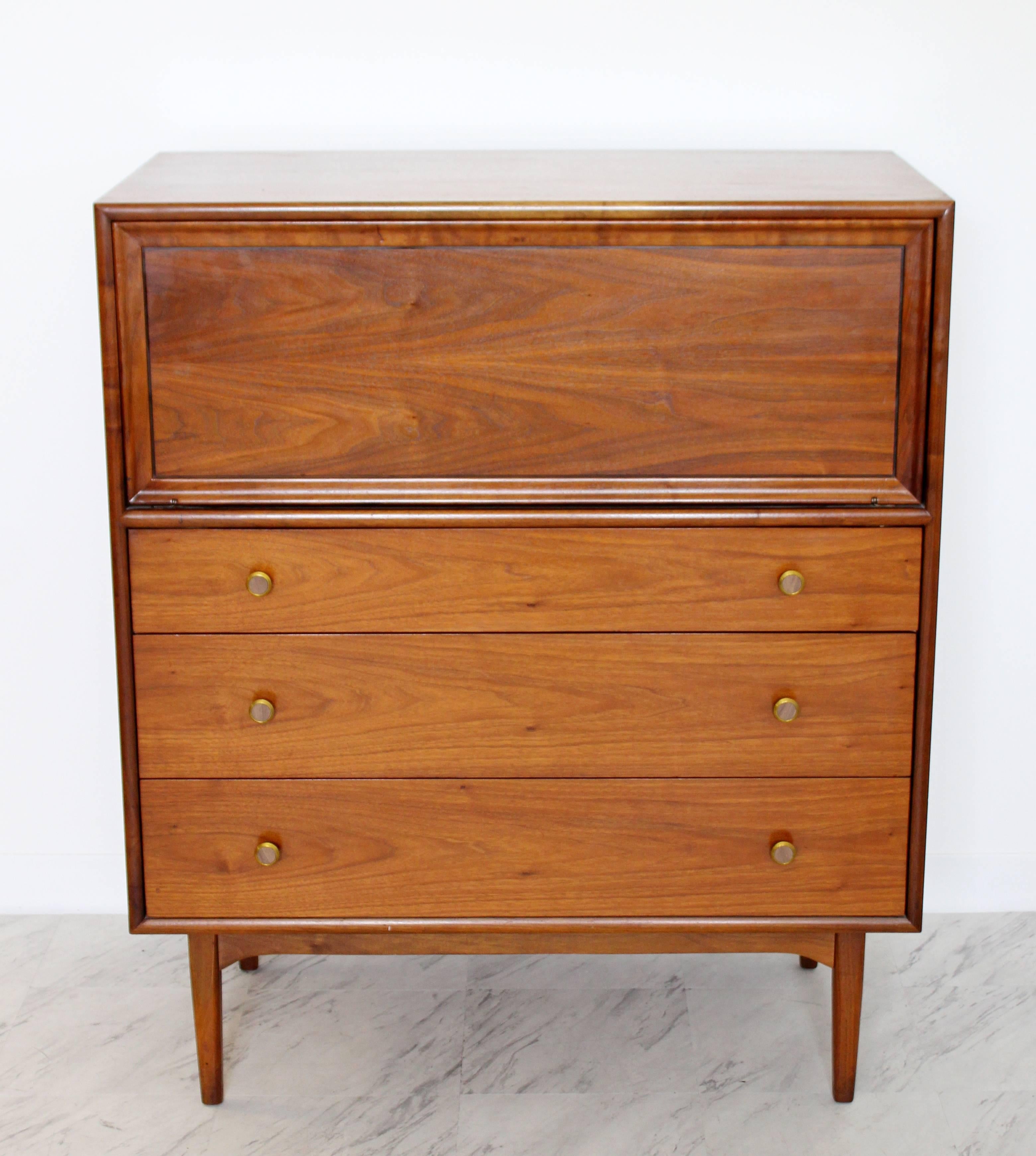 For your consideration is a gorgeous, walnut highboy with three outer drawers that have brass and wood knobs, designed by Kipp Stewart for Drexel, Declaration, circa 1965. In excellent condition. The dimensions are 38