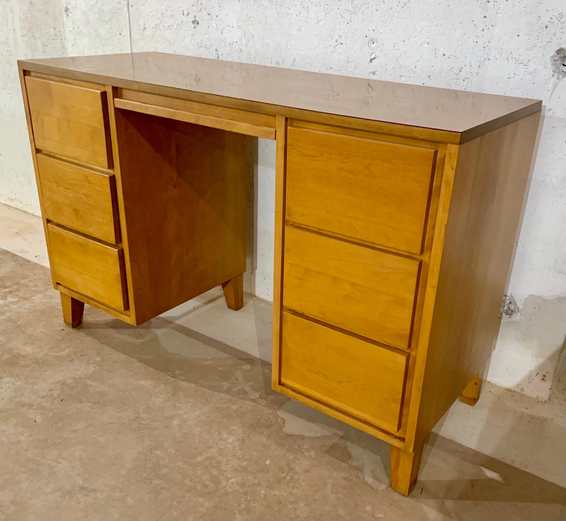 Mid century kneehole desk features a formica top for extra durability. Six drawers with one center drawer. It’s smaller size is perfect for a smaller office or apartment.