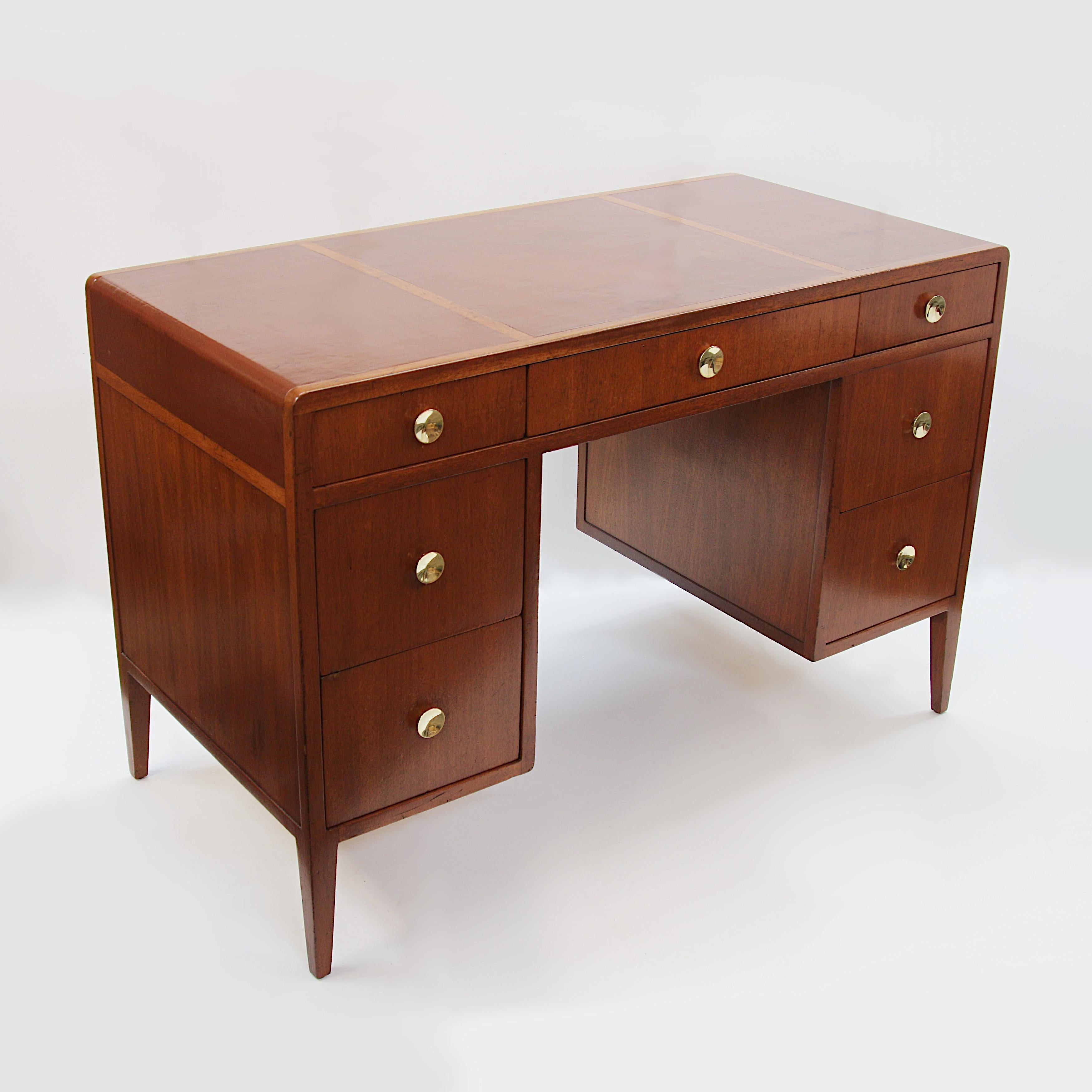 Rare, early kneehole writing desk by Edward Wormley for Dunbar. Desk features Mahogany and oak construction, solid brass hardware, inlaid leather top and unique, rounded 'waterfall' ends. A nice little desk packed with tons of charm and dimensions