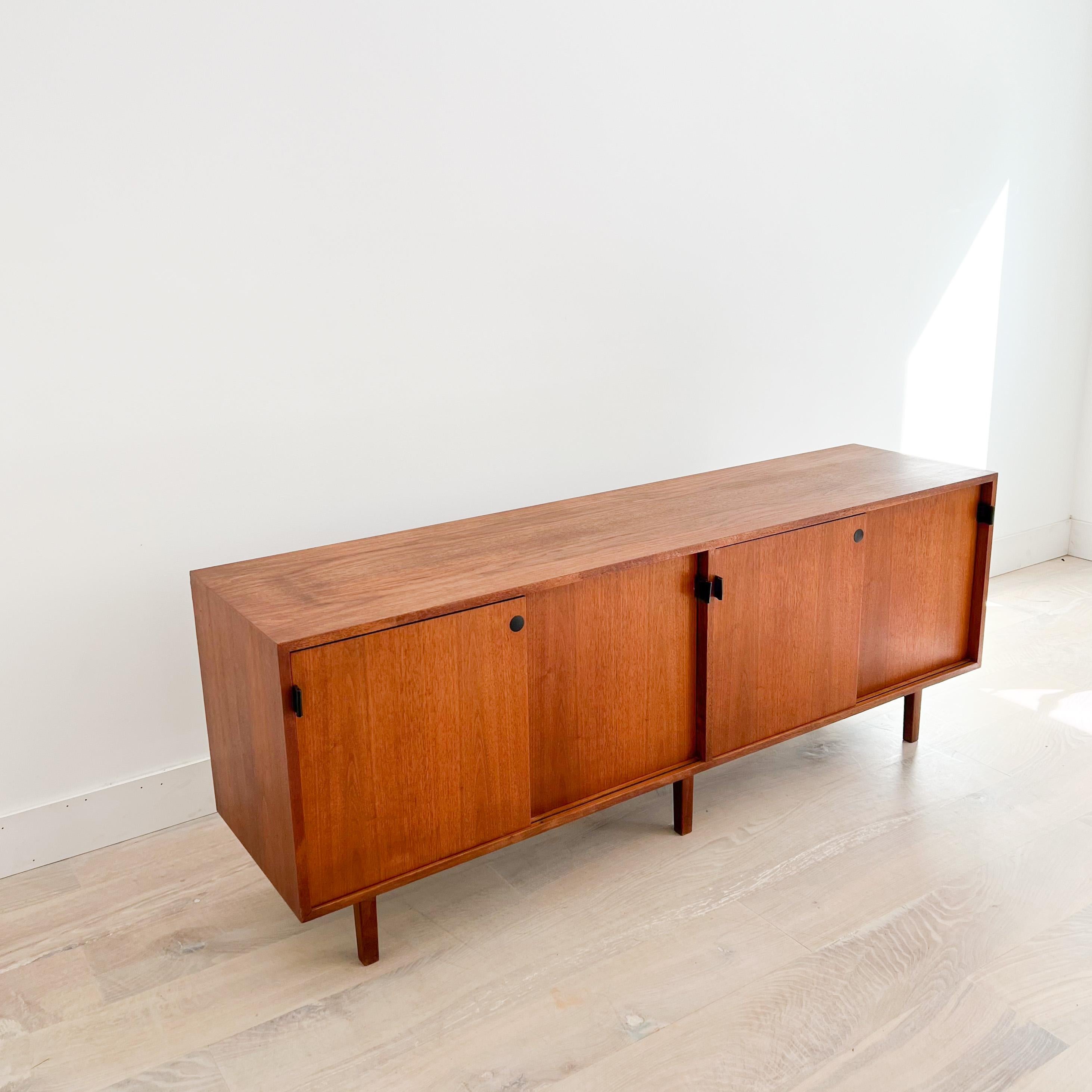 Mid-Century Modern credenza with black leather door pulls by Knoll. It’s kind of rare to find these with the wood veneer tops rather than the Formica. The top has been sanded and restored. Some light scuffing/scratching/small areas of veneer repair