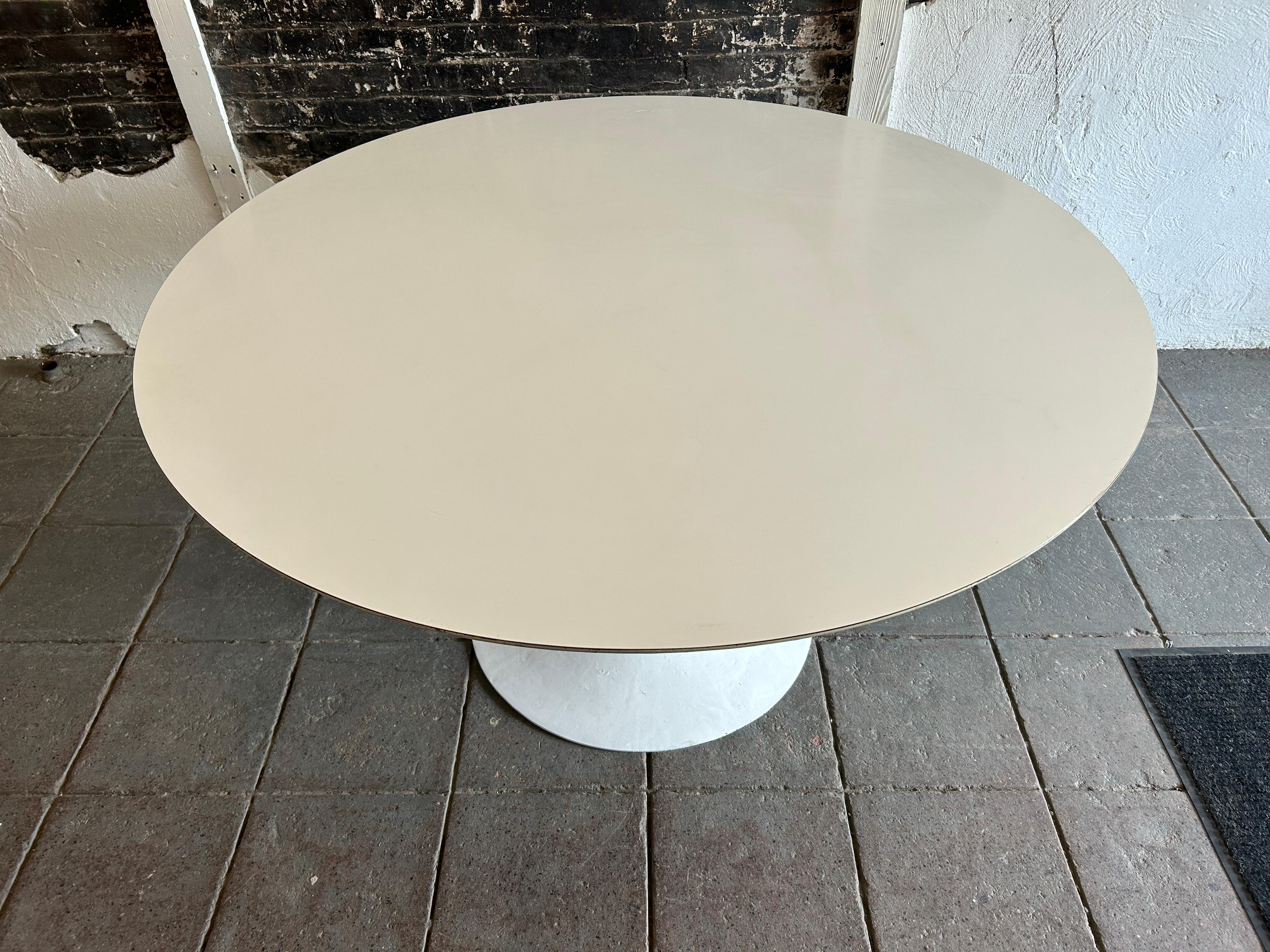 Mid-Century Modern Knoll laminate tulip dining table by Eero Saarinen. Great Indoor or outdoor Dining table. Glossy white Laminate top on a very heavy early steel base. The Table to Measures 54