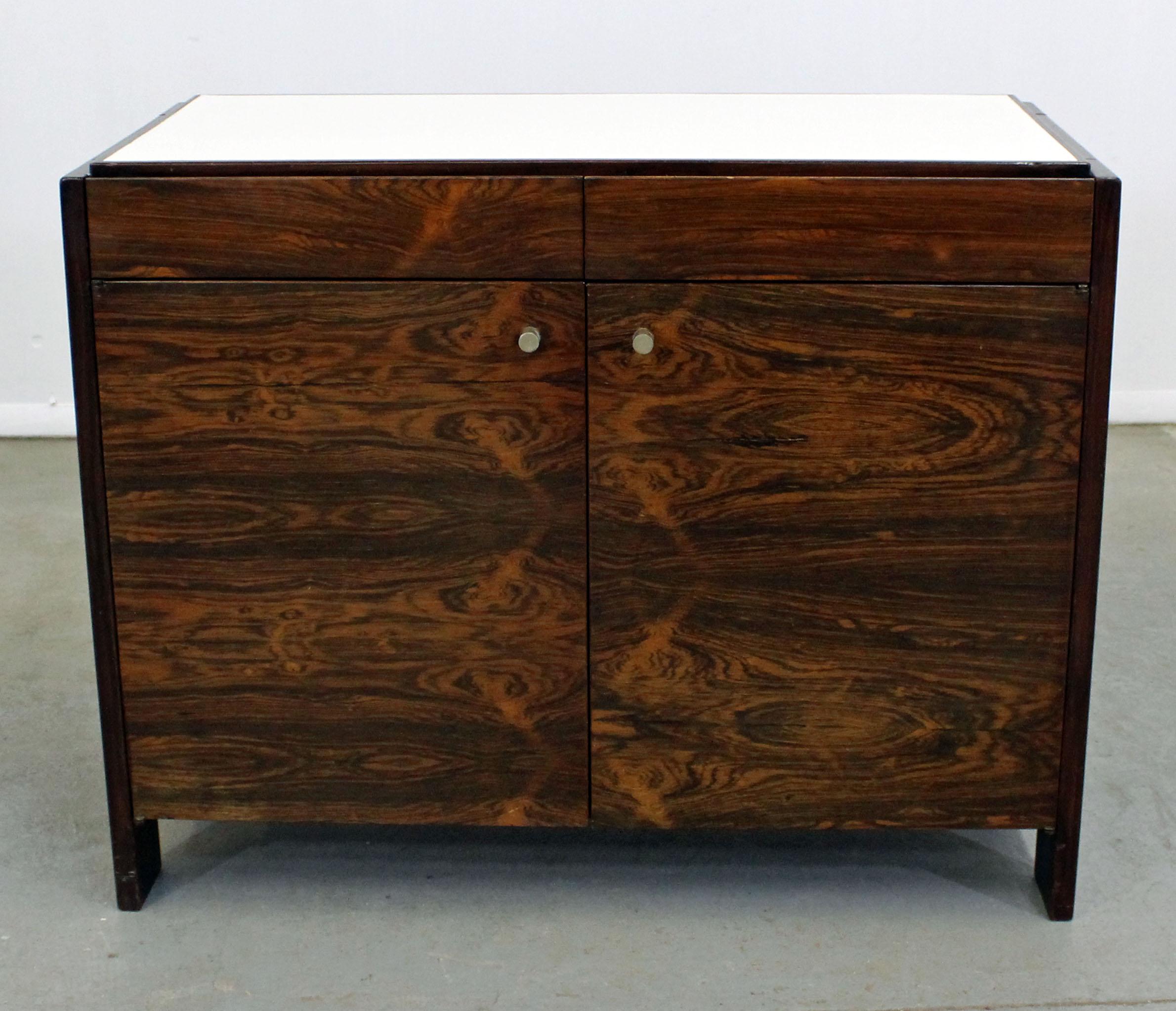 What a find. Offered is a gorgeous Mid-Century Modern rosewood server with a white laminate top by Knoll. This server features two drawers atop and two doors with adjustable shelving inside. It is in excellent condition for its age, shows some age