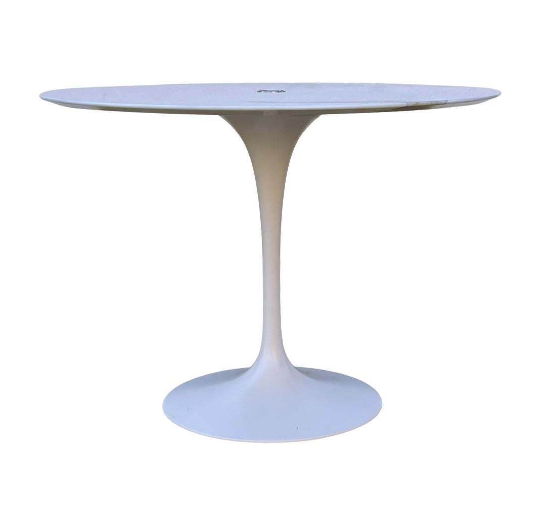 A Saarinen for Knoll Tulip Table designed for the work space having a center hole to run computer and telephone wires. It features beautiful calacatta marble top with white pedestal base. 