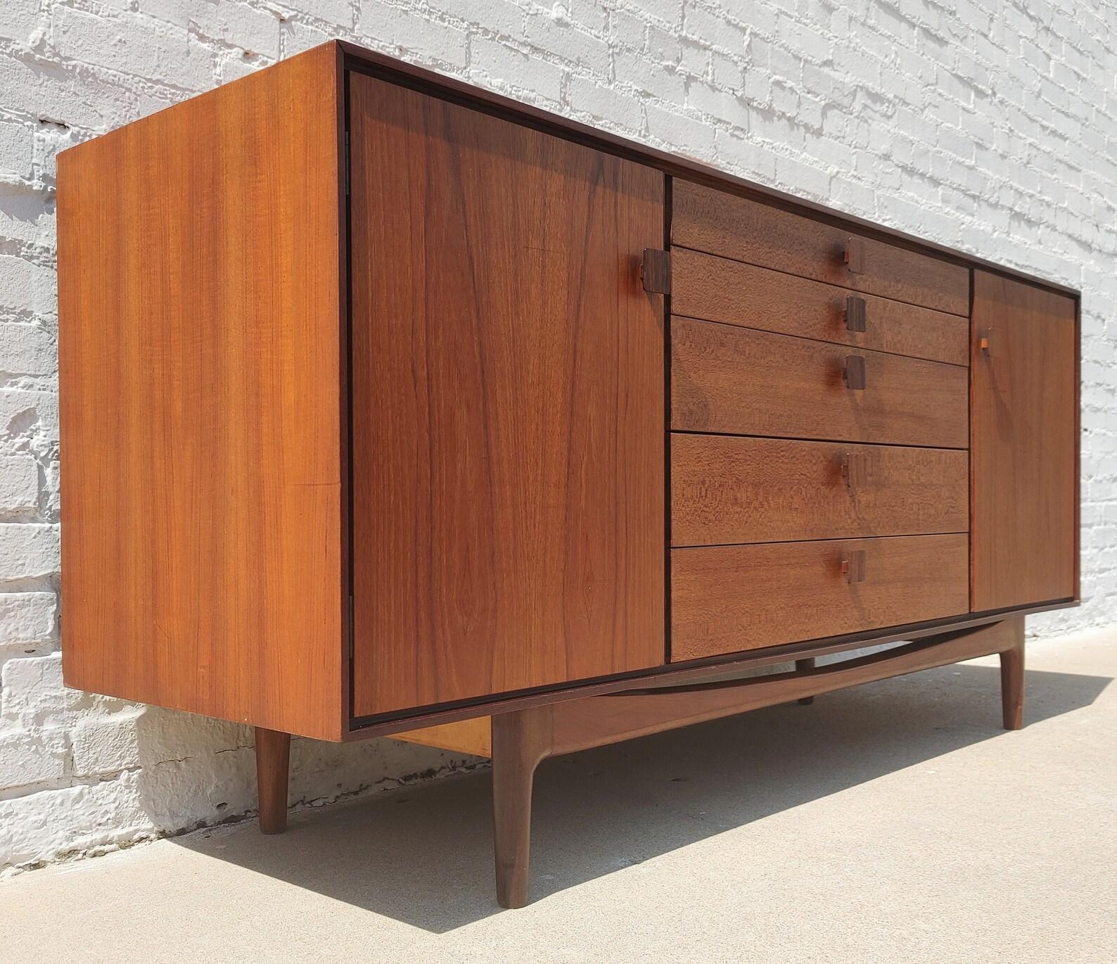 Mid Century Modern Kofod Larsen Teak Sideboard
 
Above average vintage condition and structurally sound. Has some expected slight finish wear and scratching. Top has a couple light discolorations. Outdoor listing pictures might appear slightly