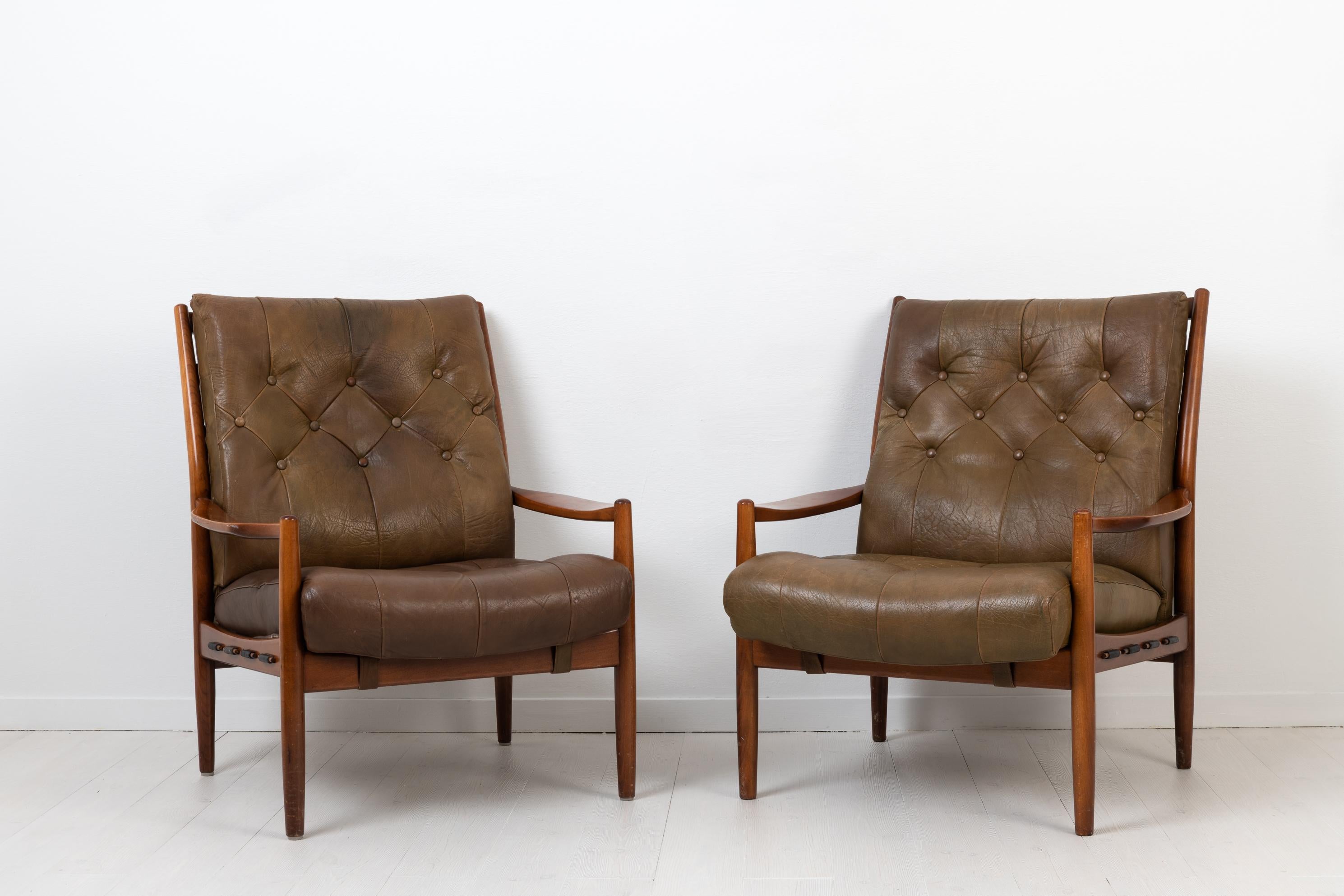 Pair of armchairs 'Läckö Hög' by Ingemar Thillmark for OPE. The chairs are from the 1960s and has a frame of stained beech and deep padded cushions upholstered in leather. They are in good vintage condition with some signs of wear such as marks and