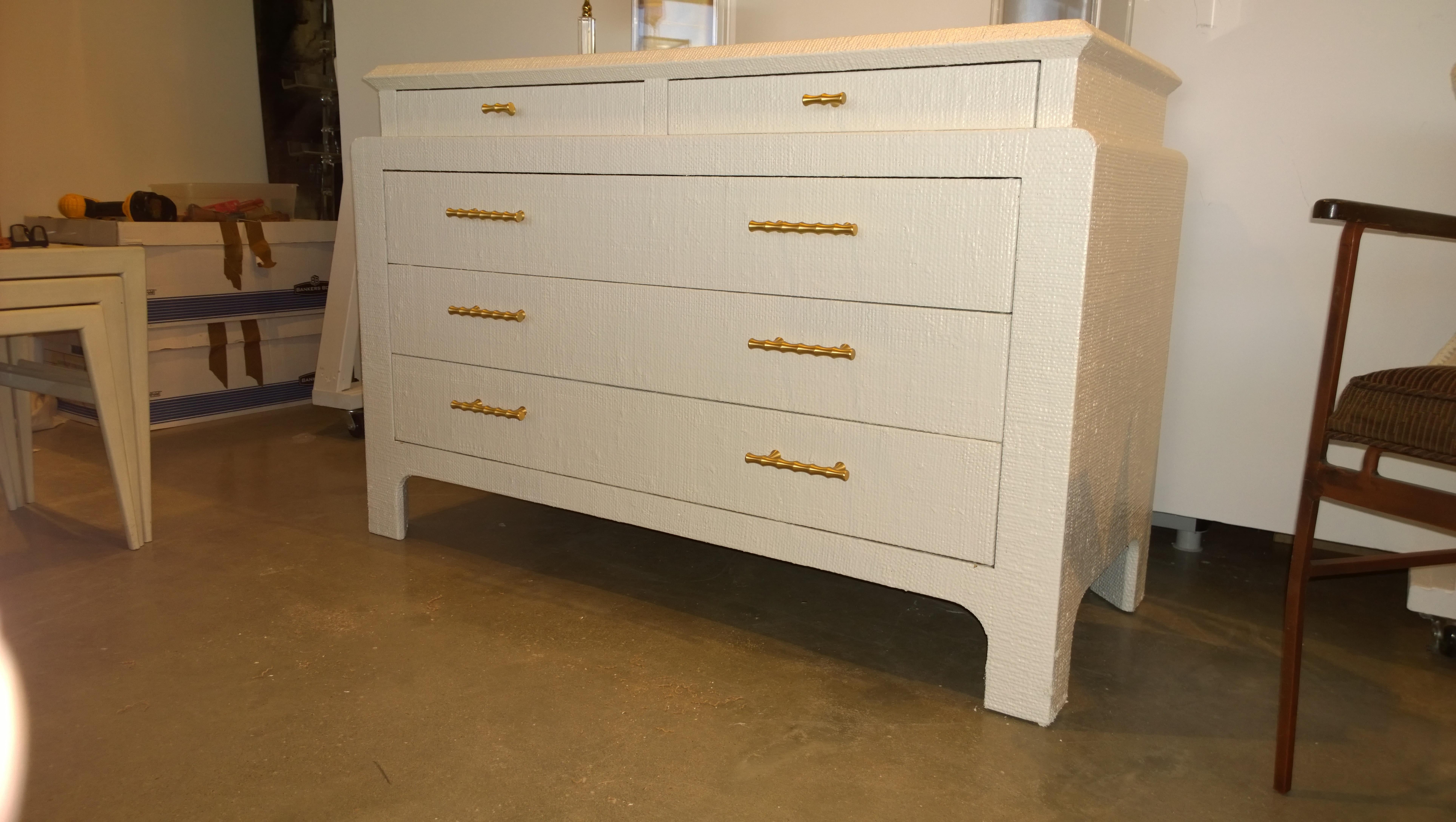 Offered is a chinoiserie style Mid-Century Modern Harrison Van Horn newly lacquered in creamy white grasscloth dresser with new brass bamboo style hardware pulls. This piece is finished at the back and could float in any space. This elegant yet