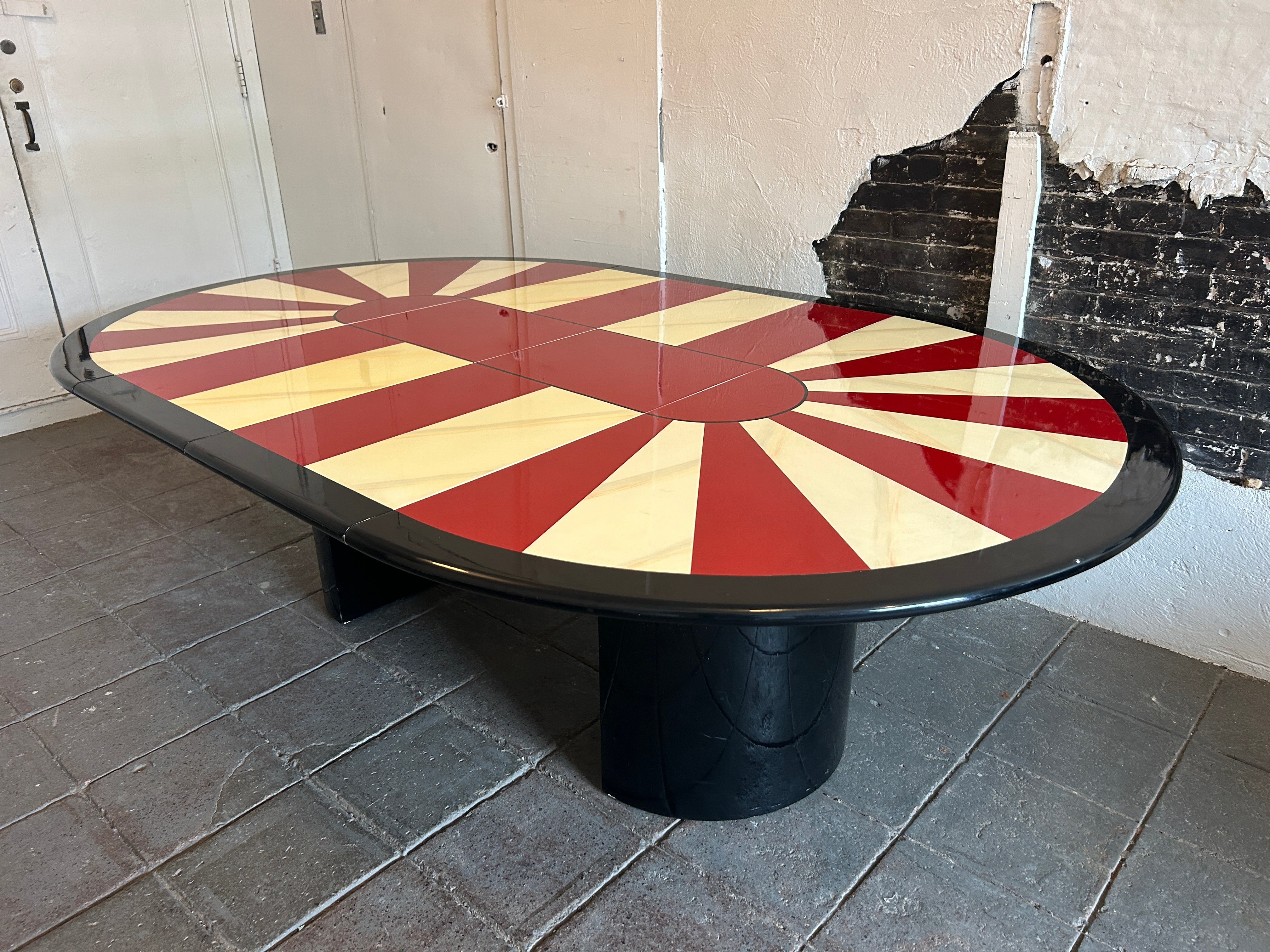 Table de salle à manger ronde laquée rouge, blanche et noire de style post-moderne du milieu du siècle, avec (2) portes-fenêtres. Attribution à Karl Springer. Magnifique étoile éclatée de couleur rouge et blanche avec base inférieure ronde en laque