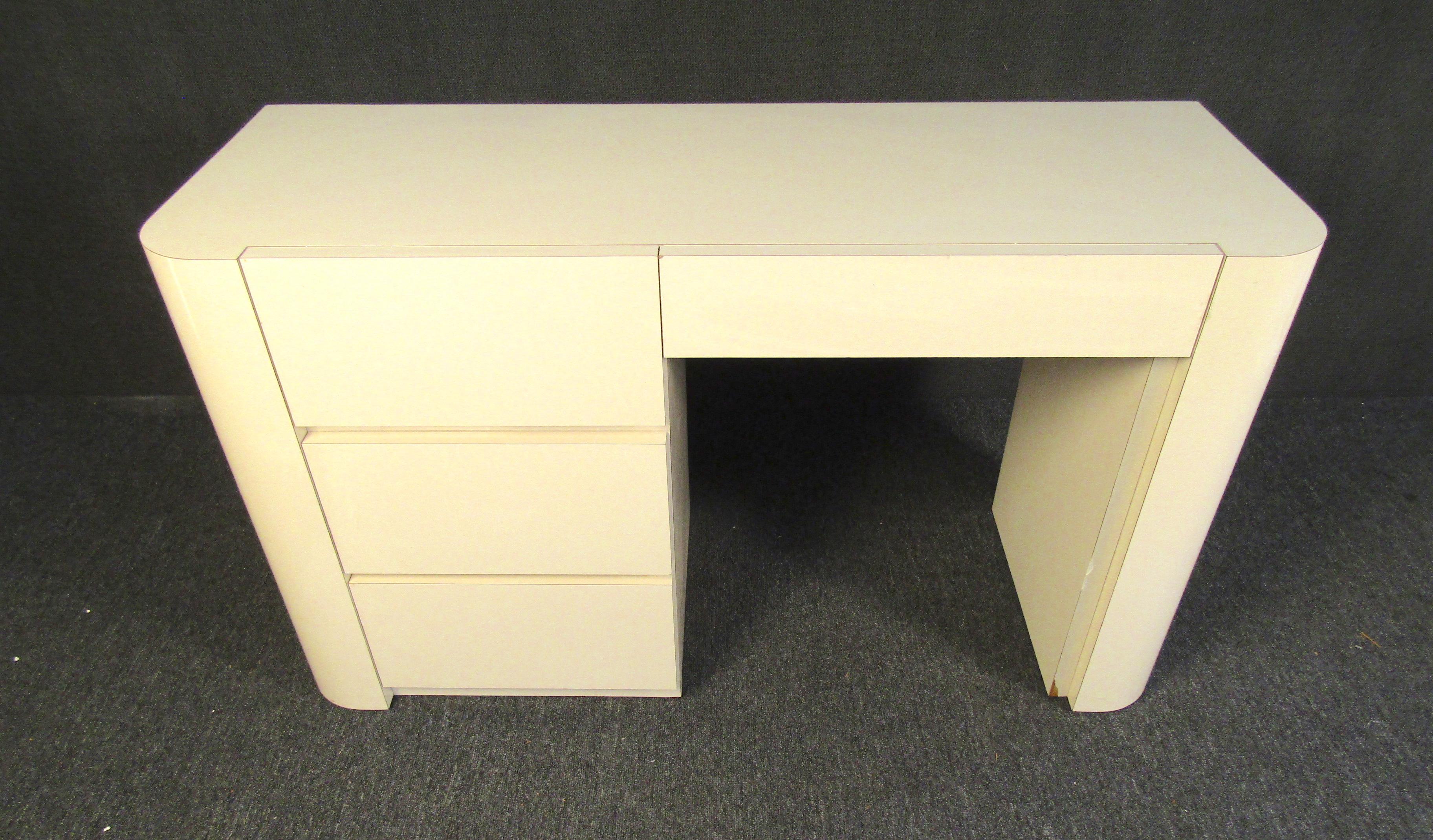 With a sleek design and understated cream color, this Mid-Century Modern desk has four drawers for storage and a large top to work on. Please confirm item location with seller (NY/NJ).