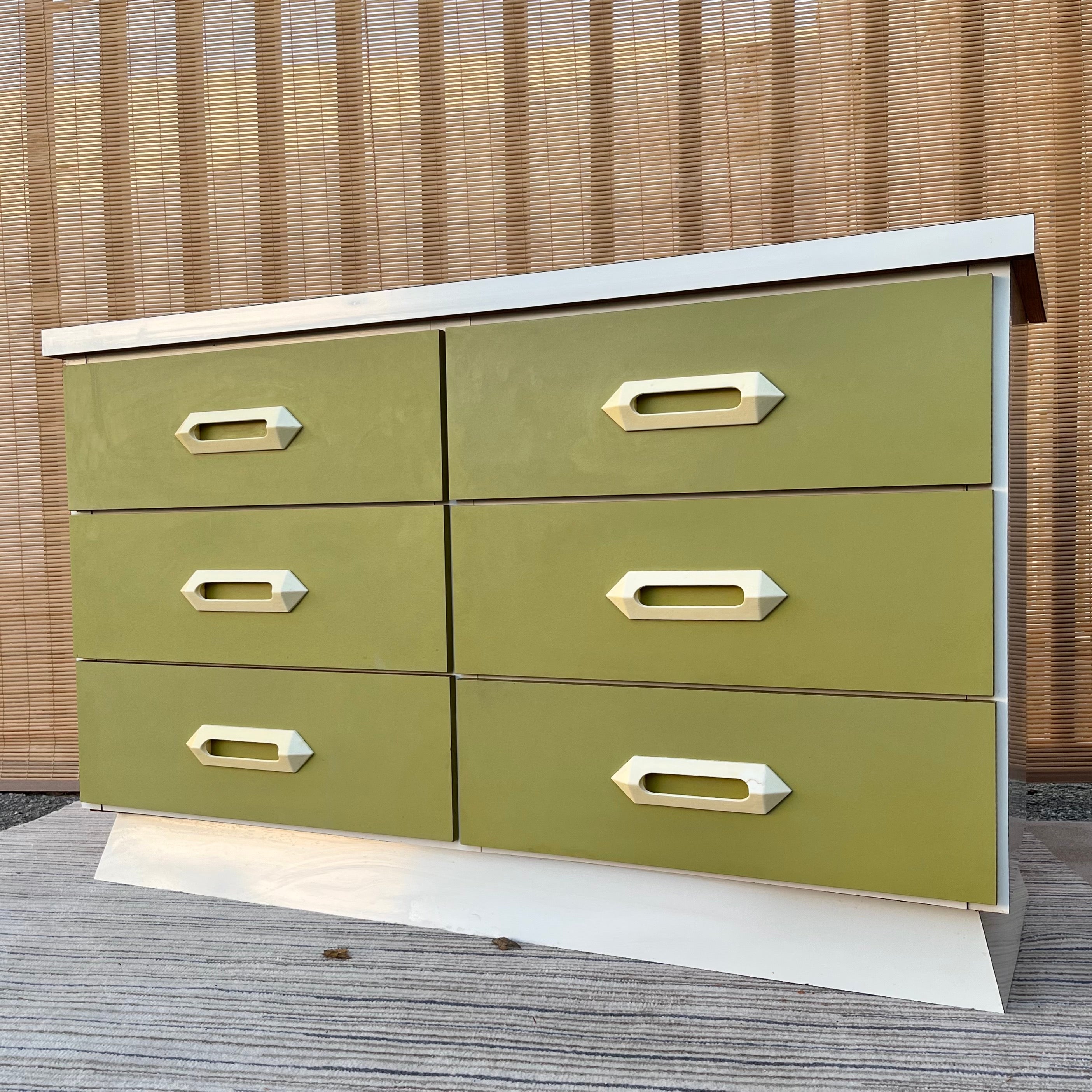 Vintage Mid Century Modern Laminated Compact Dresser. Circa 1960s
Features a compact size perfect for any space limited area, six drawers laminated with avocado green formica with off white plastic handles, and a body and base laminated with a