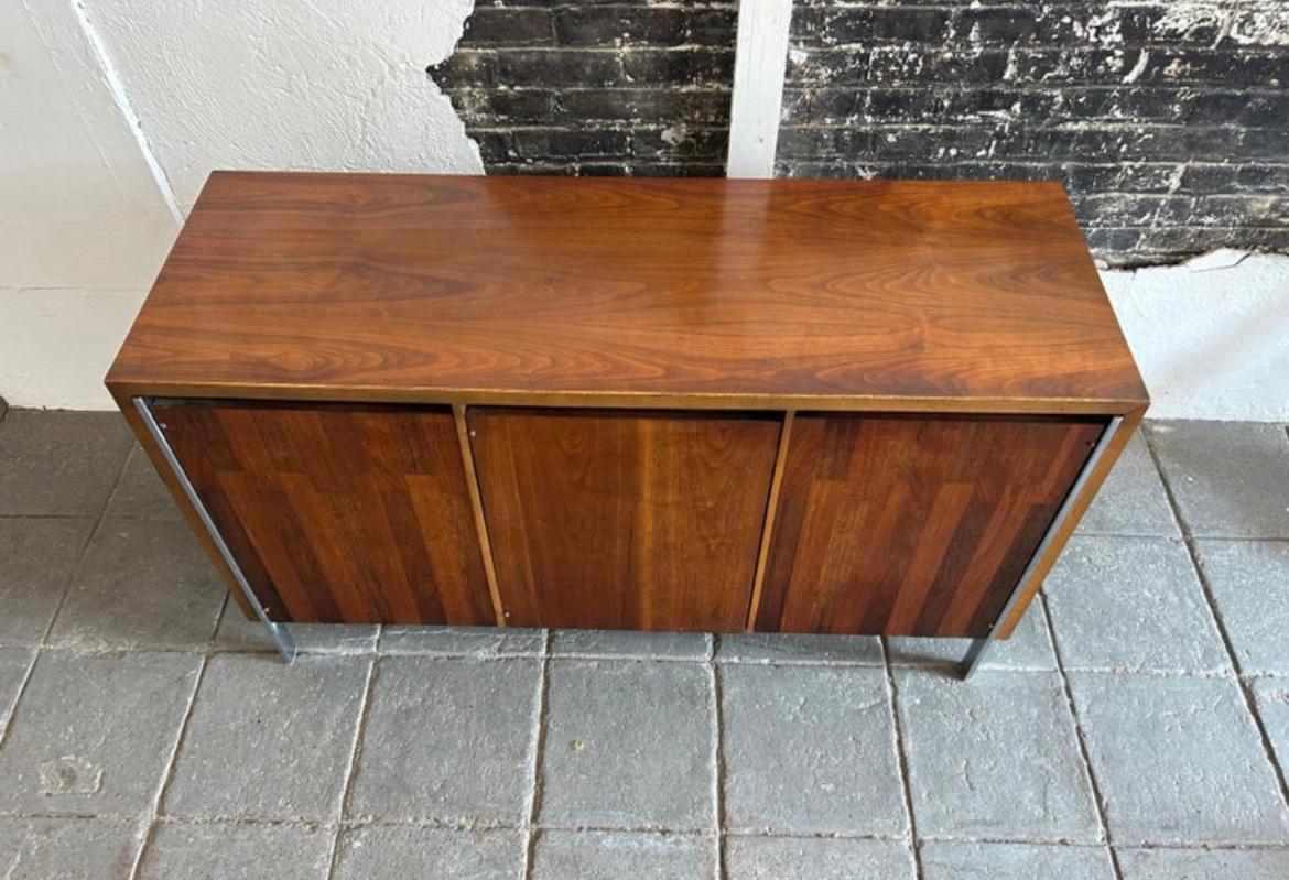 Rare Mid-Century Modern Lane patchwork walnut credenza sideboard circa 1970s well built. Has 3 front cabinet doors with 2 drawers behind the right door and shelves behind the 2 left doors. Sits on 5 flat bar chrome legs. Made in USA by Lane