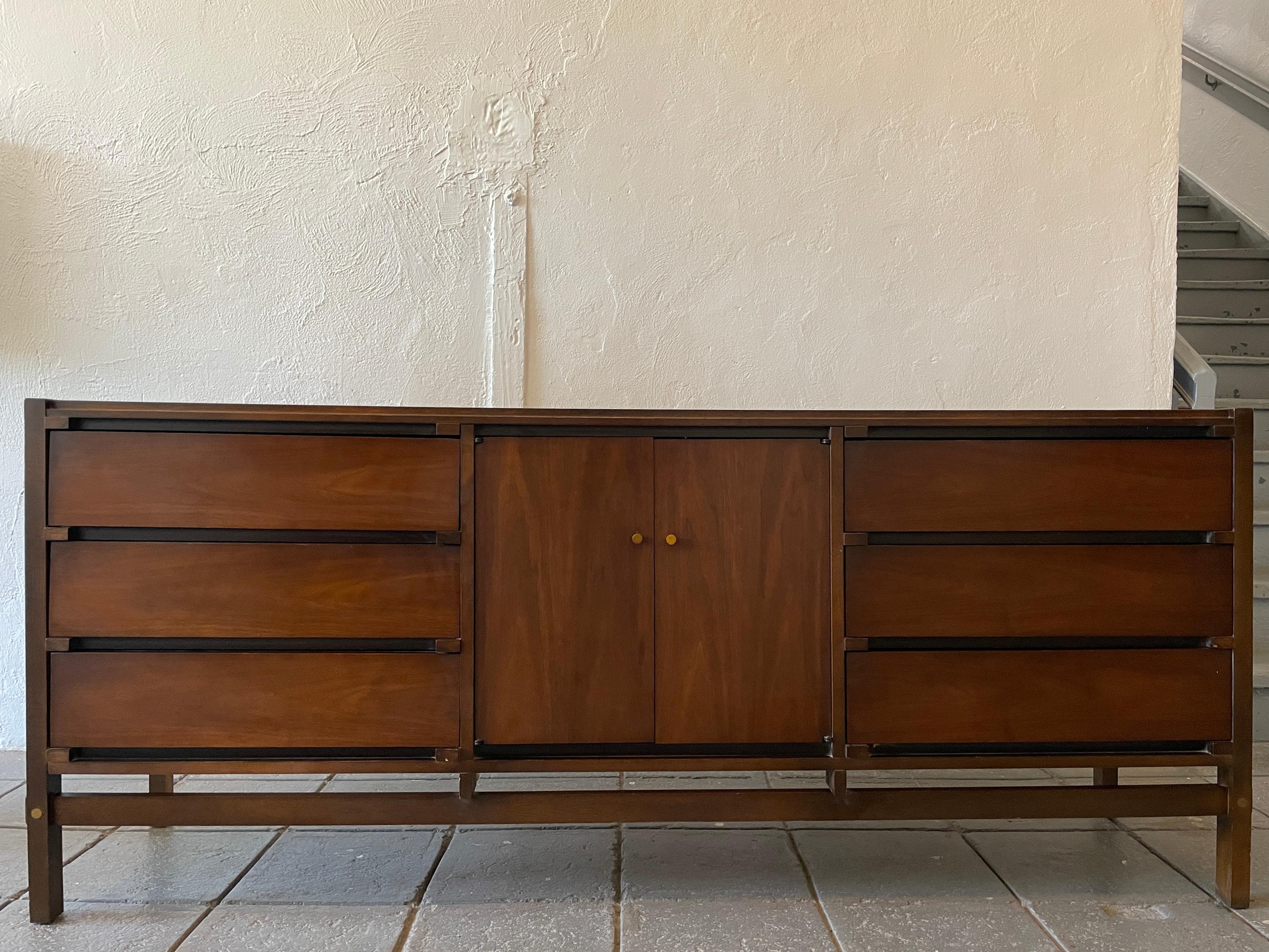 Mid-Century Modern Lane 9 drawer walnut credenza or dresser circa 1960s well built. Has six exposed drawers and 3 center drawers behind 2 cabinet doors with solid brass pulls. Made in USA by Lane Furniture co. Labeled. Located in Brooklyn NYC.