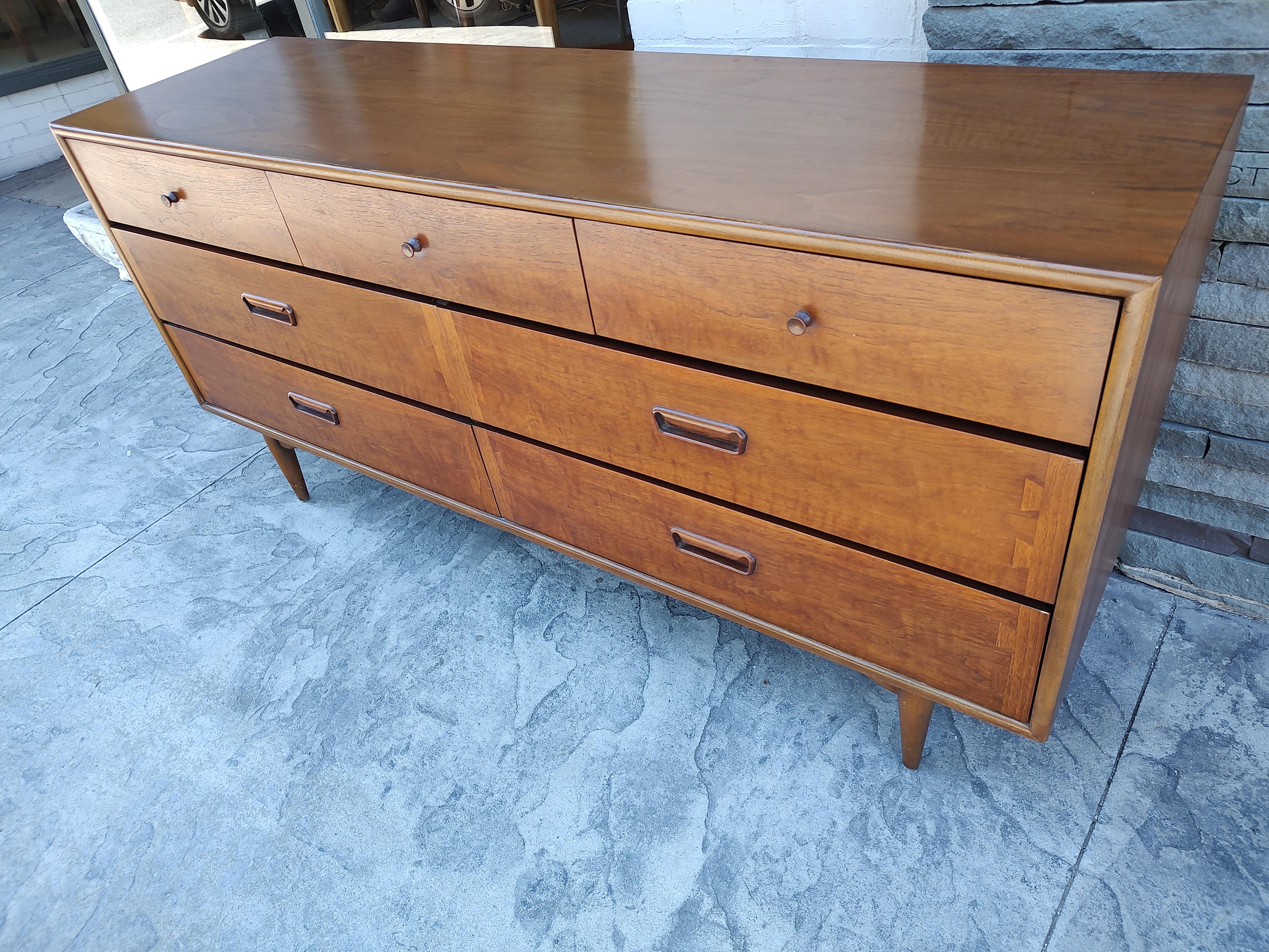 Fabulous and in amazing condition with original finish. 7 Drawer dresser, lots of storage in this beauty by Andre Bus for Lane. Sculpted pulls with exaggerated dovetail design on lower drawer fronts is now a classic. We have the matching tall