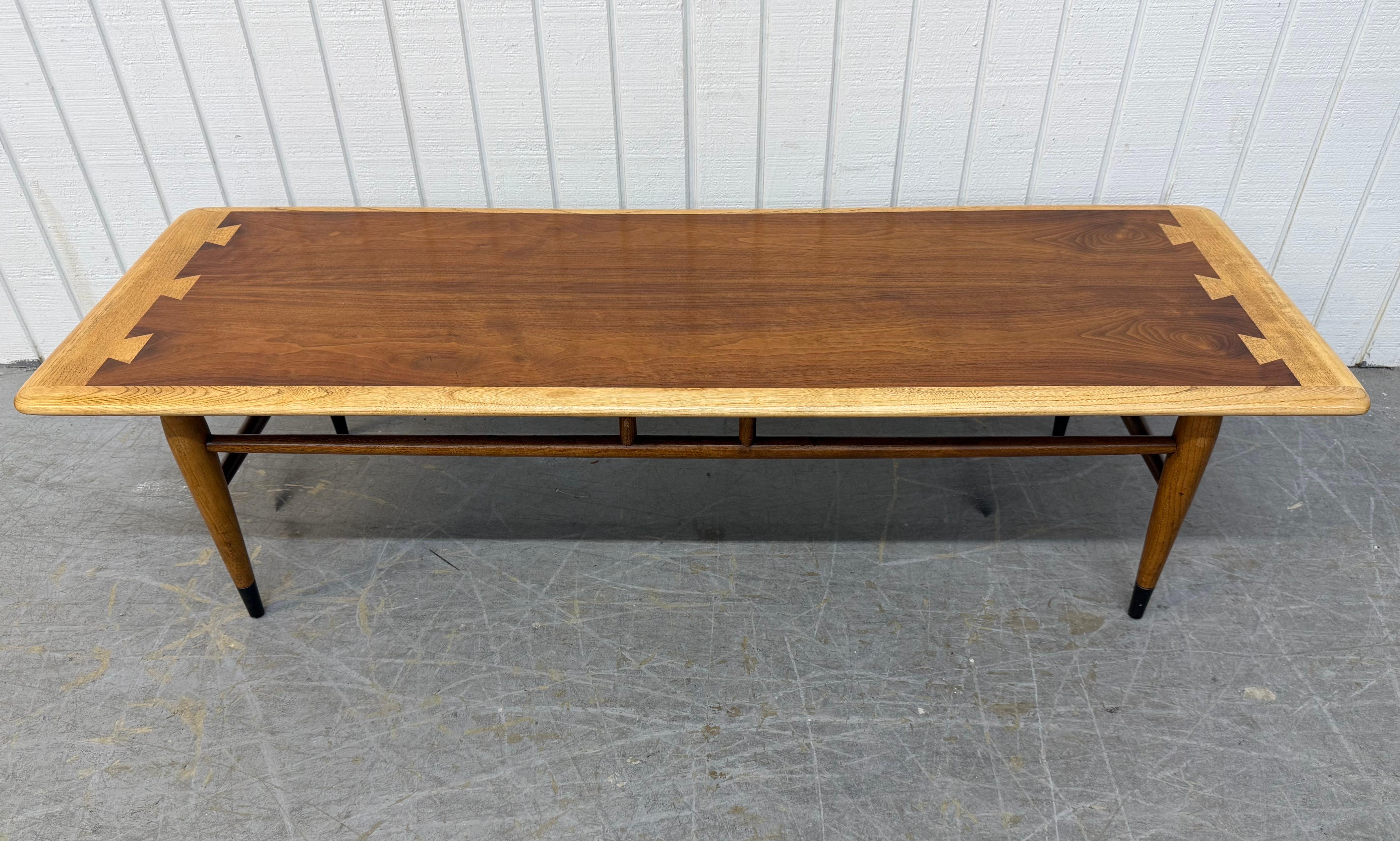 Cette annonce concerne une table basse en noyer Lane Acclaim de style moderne du milieu du siècle. Ce meuble présente un design rectiligne, un plateau rectangulaire à queues d'aronde incrusté, des pieds modernes avec une base à brancard, et une