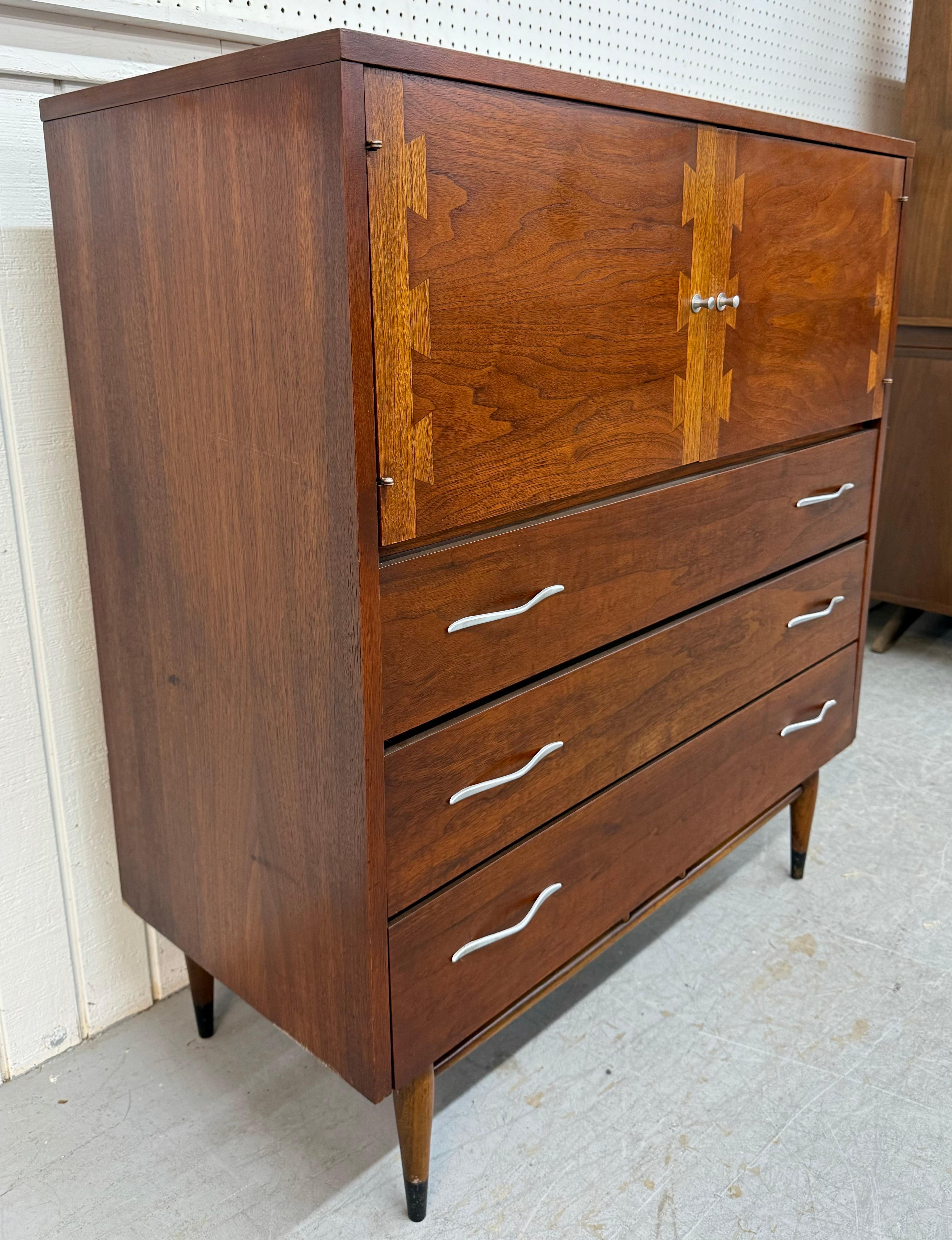 This listing is for a Mid-Century Modern Lane Acclaim Walnut High Chest. Featuring a straight line design, two doors with the iconic Acclaim dovetails that open up to storage space , original chrome hardware, three drawers for more storage, modern
