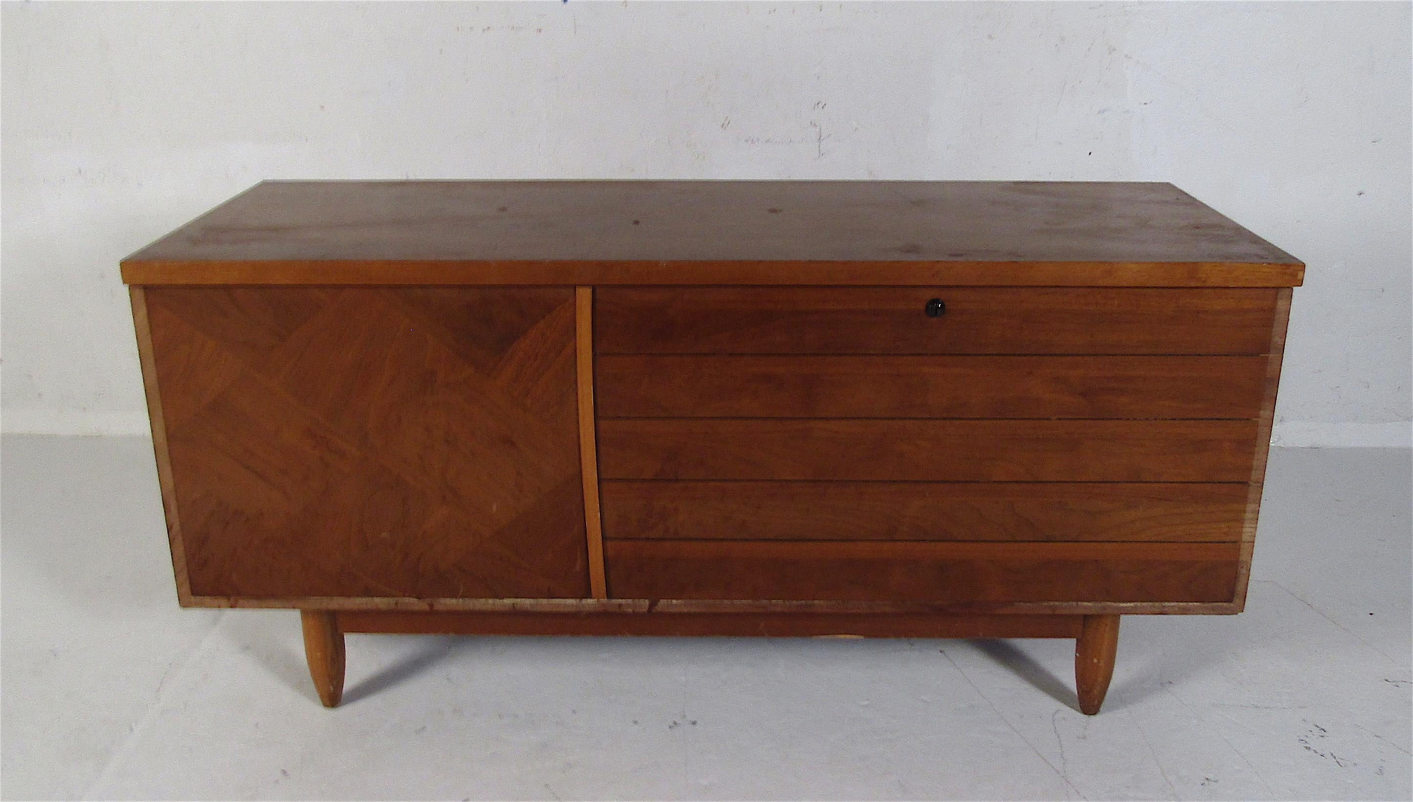 This beautiful vintage modern cedar chest was designed by Lane Furniture. An iconic piece that has a shelf that floats out when the top is lifted. The felt lining in the shelf, diamond inlaid woodgrain front, and stubby tapered legs show quality