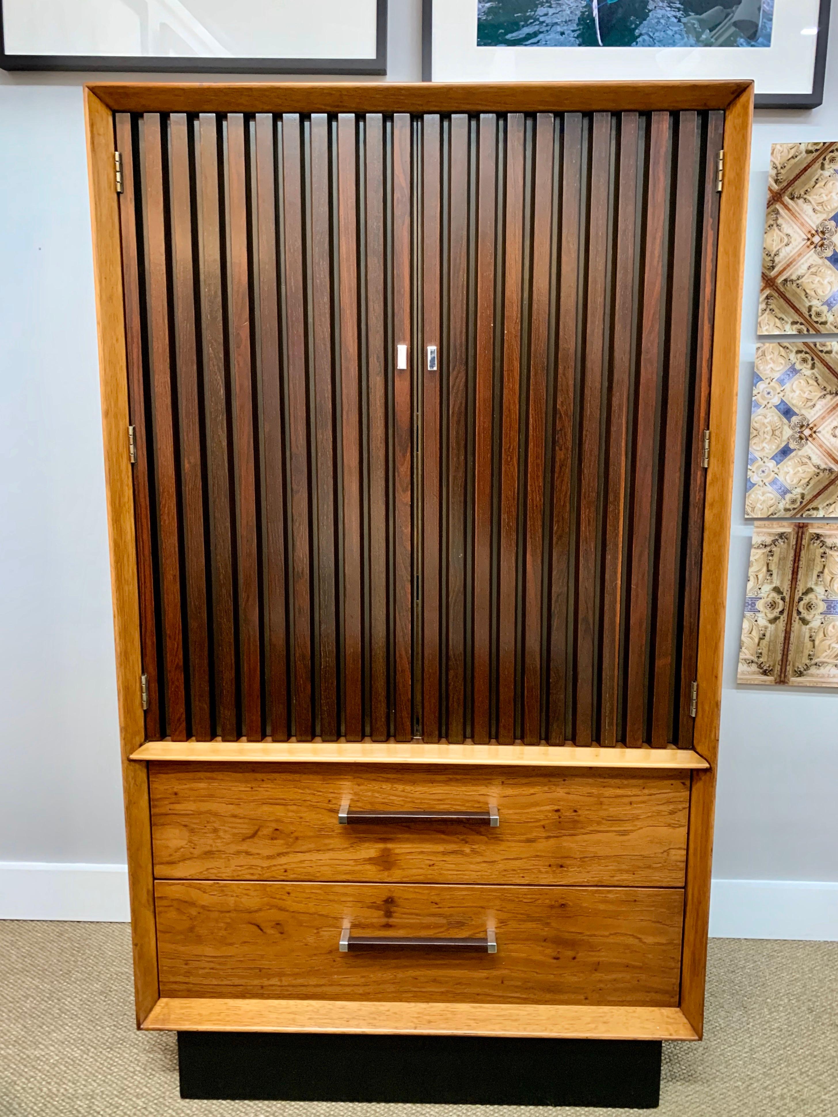 Elegant signed Lane Furniture wardrobe armoire. An iconic Brutalist cabinet with drawers at
bottom and doors at top that open to show two drawers and them cubbies at the top part.
The color scheme is quite unusual, even for Lane, with a black base