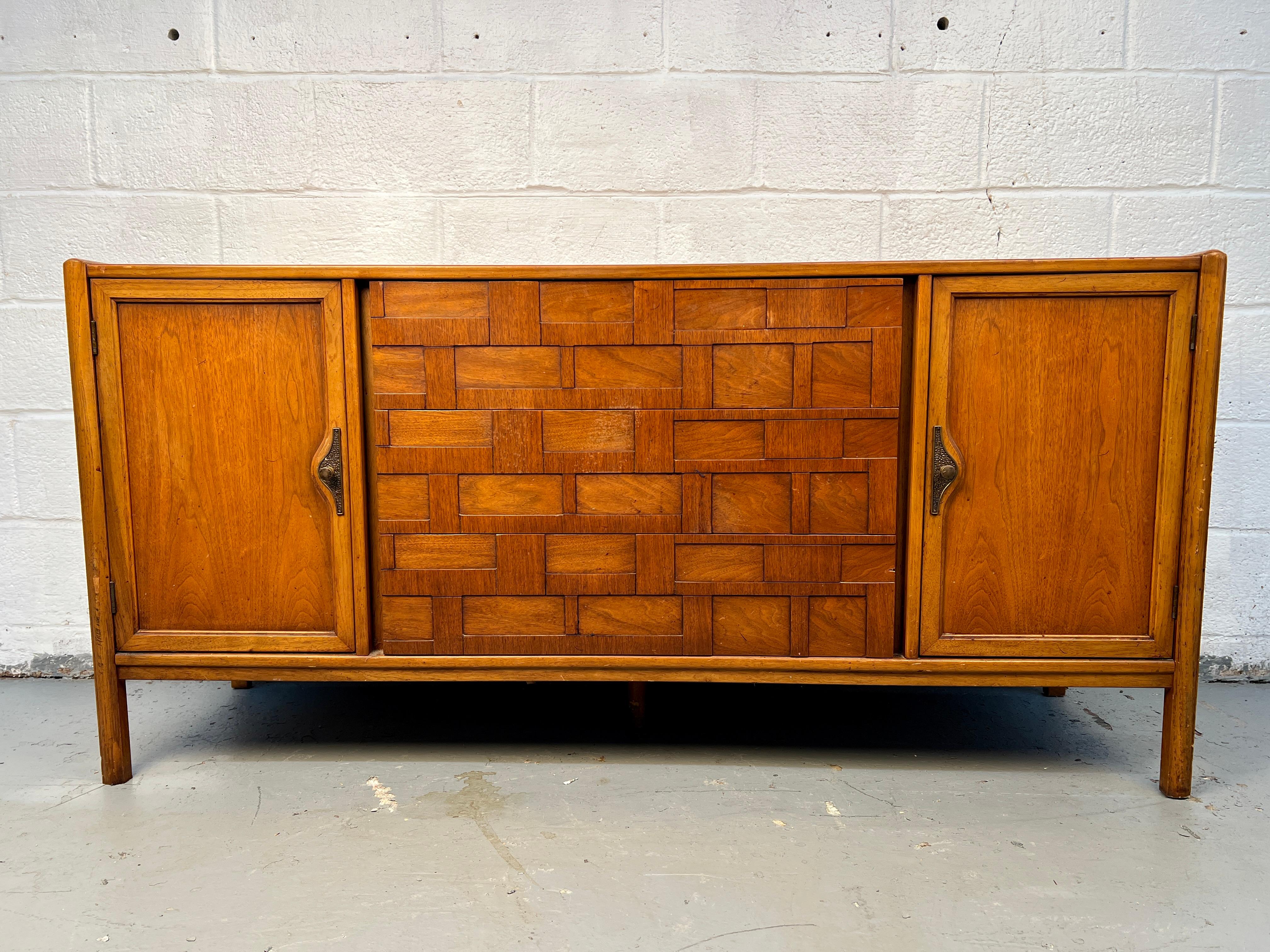 Un bel server moderno di metà secolo in noce, con cassetti a coda di rondine finemente lavorati e particolari tiretti scultorei. Un perfetto esempio di artigianato americano, che combina le calde tonalità del legno con un design elegante e