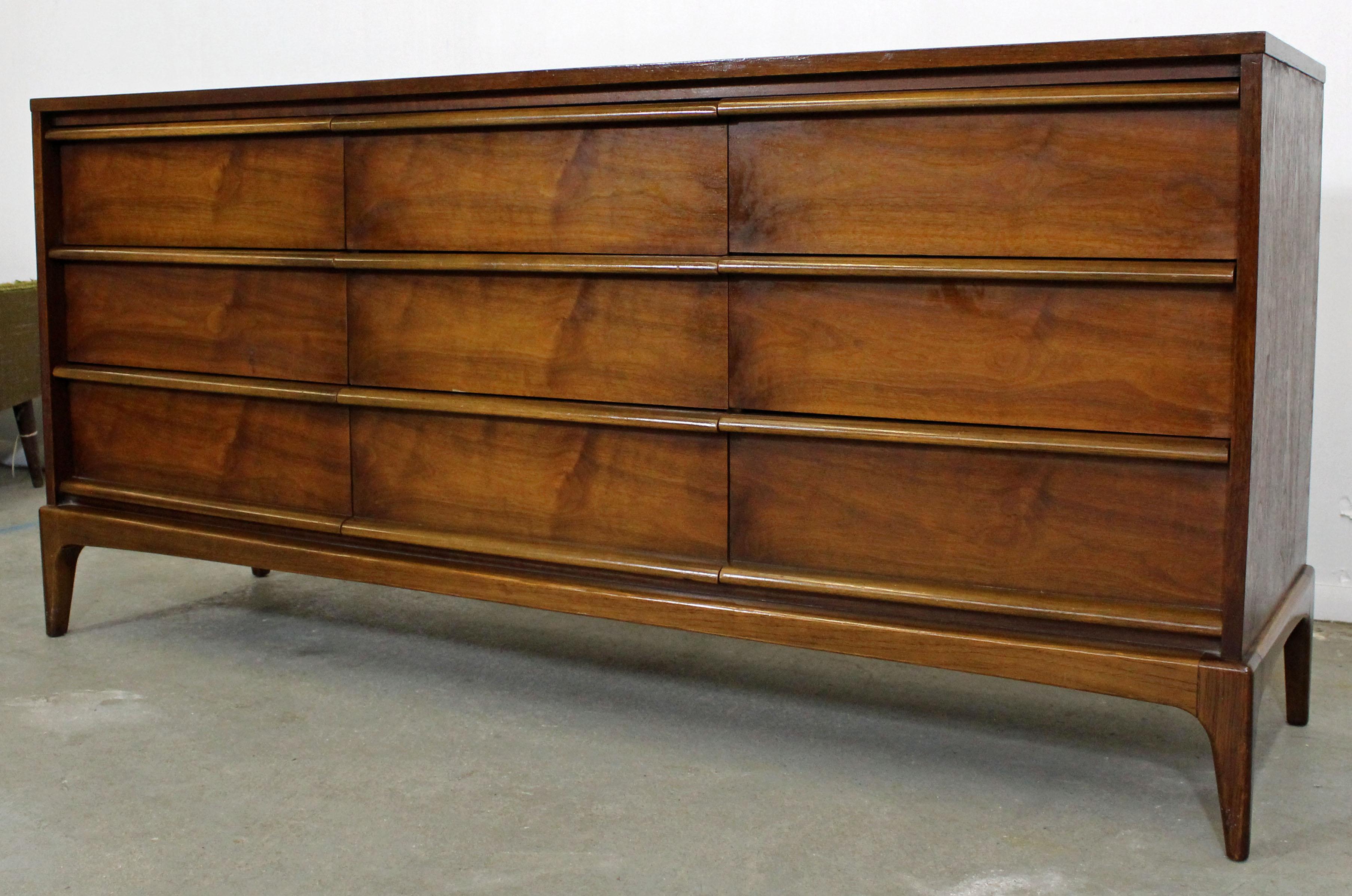 Offered is an excellent example of American Mid-Century Modern design; a walnut dresser or credenza by Lane 'Rhythm' from the 1960s. Features 9 dovetailed drawers with tapered legs and sculpted pulls. It is in excellent condition for its age with