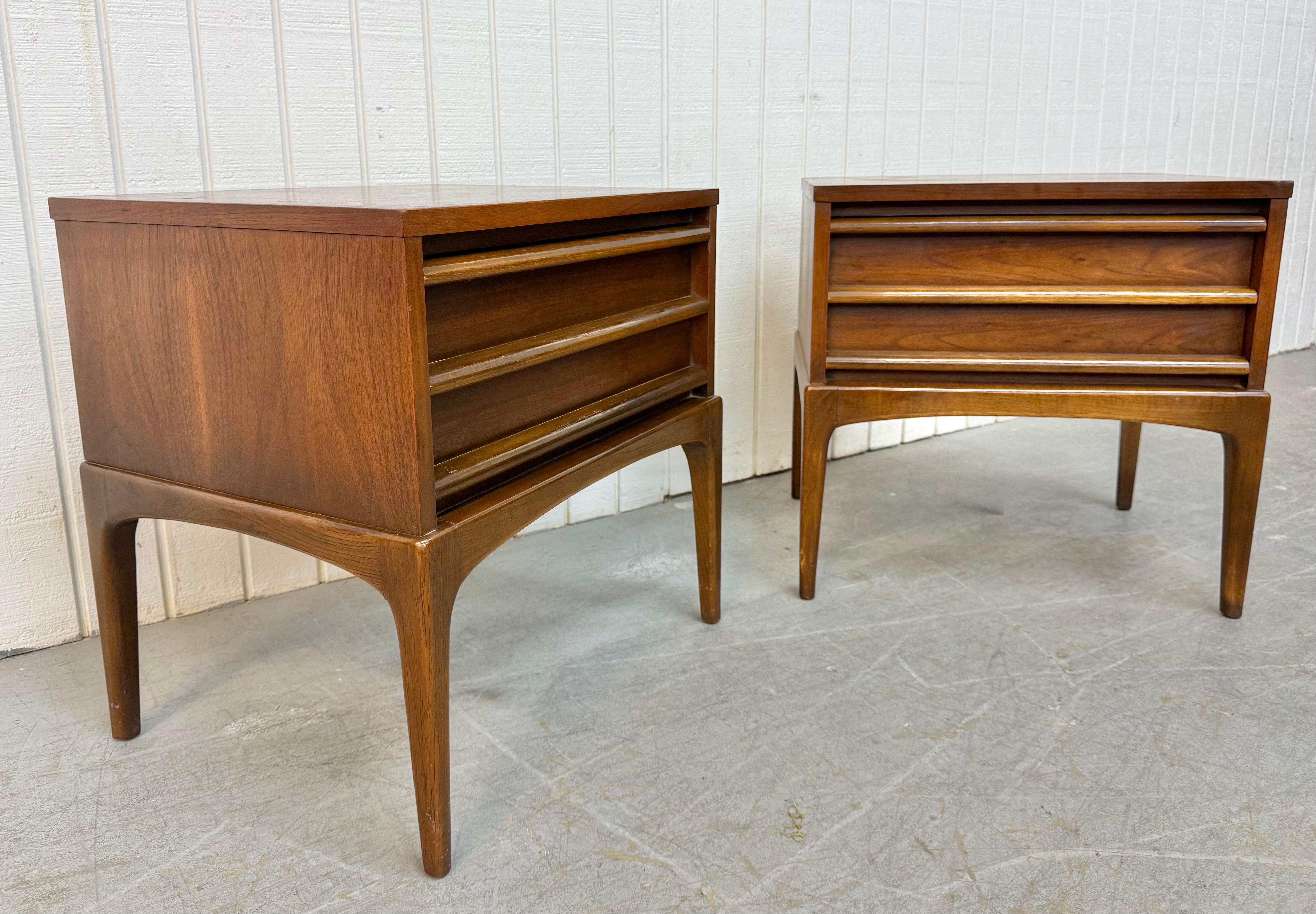 Cette annonce concerne une paire de table de nuit Lane Rhythm Walnut de style Mid-Century Modern. Elle se caractérise par un design rectiligne, un tiroir unique avec des poignées en bois, de longs pieds modernes et une magnifique finition en noyer.