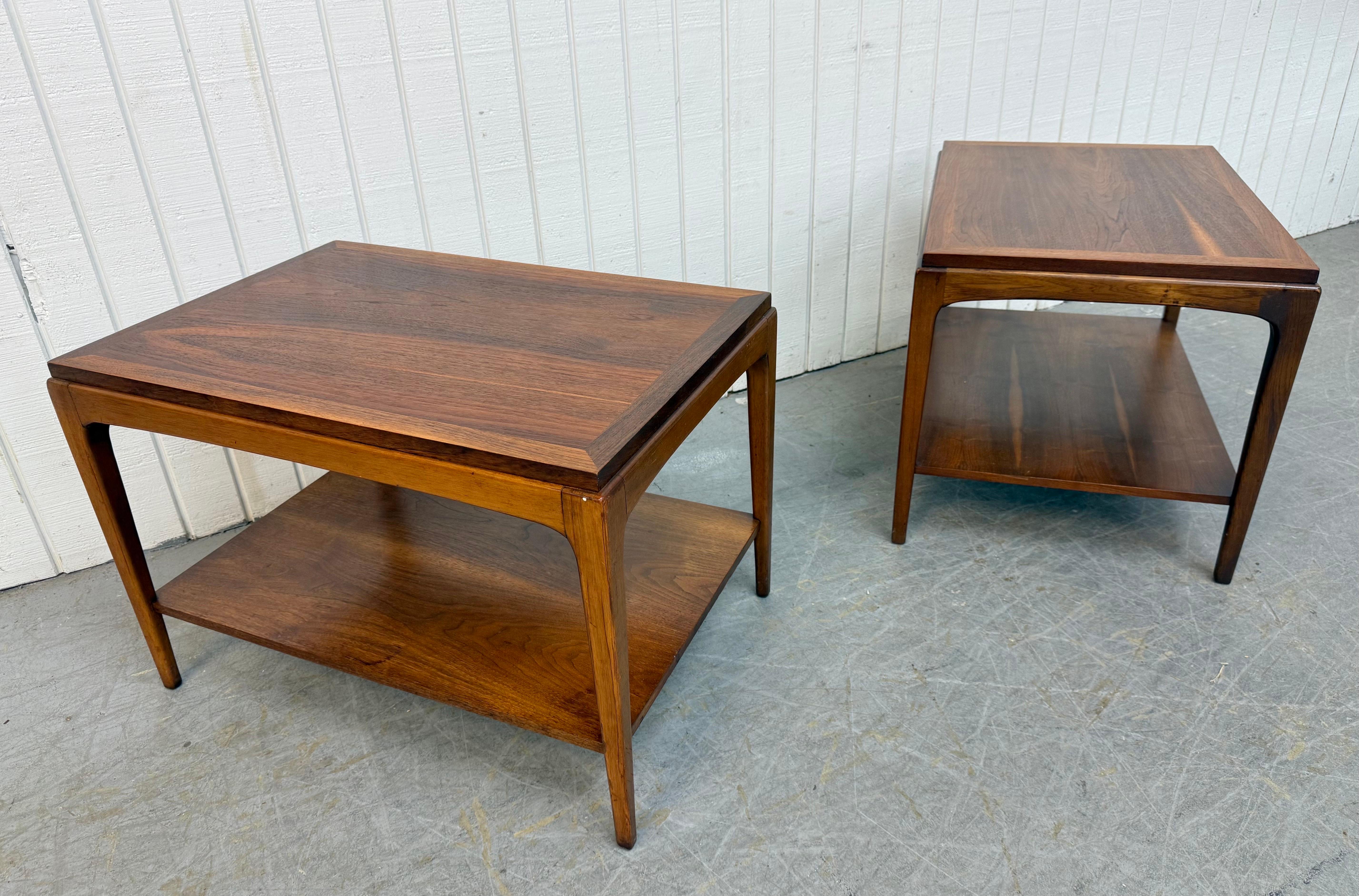 Questa inserzione si riferisce a una coppia di tavolini in noce Rhythm di Lane, in stile Mid-Century Modern. Il design è lineare, i piani rettangolari, le gambe lunghe e moderne, il ripiano inferiore per riporre gli oggetti e la bella finitura in