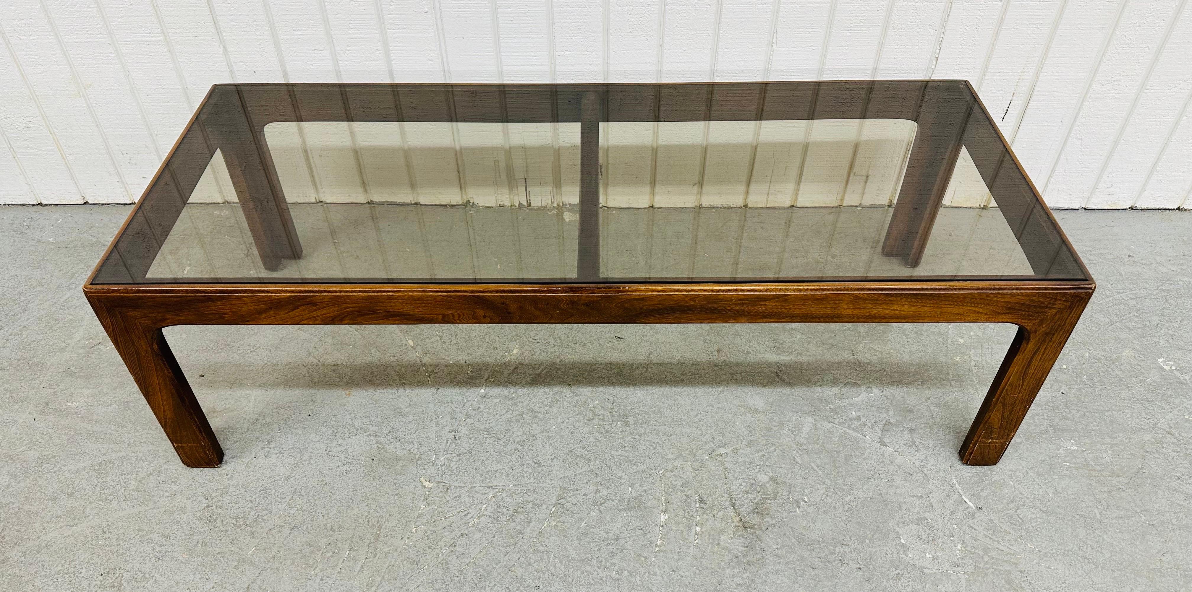 This listing is for a Mid-Century Modern Lane Style Smoked Glass Coffee Table. Featuring a straight line design, rectangular smoked glass top, walnut base with four attached legs, and a beautiful walnut finish. This is an exceptional combination of