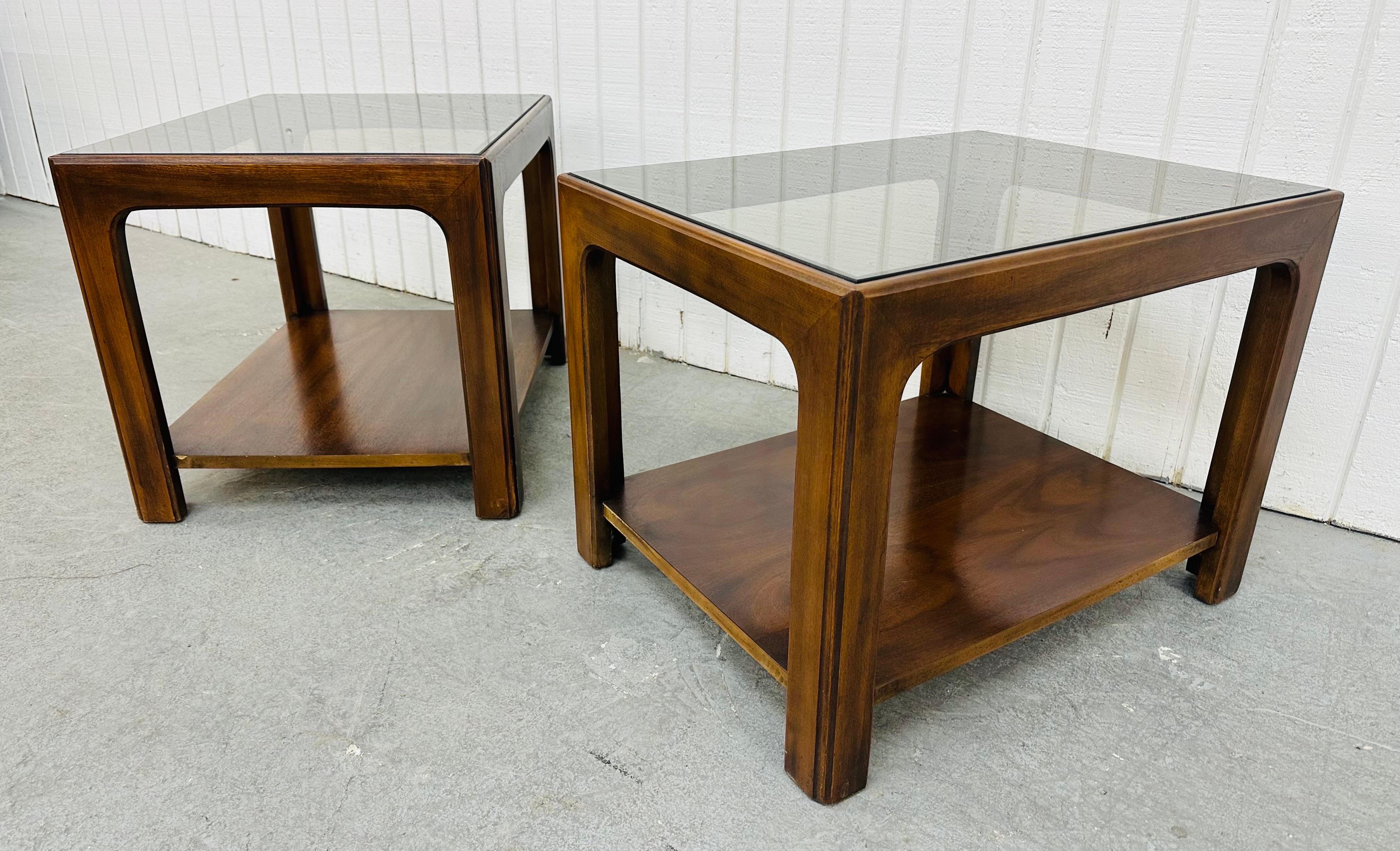 This listing is for a pair of Mid-Century Modern Lane Style Smoked Glass Side Tables. Featuring a straight line design, smoked glass rectangular top, modern legs, a bottom shelf for storage, and a beautiful walnut finish. This is an exceptional