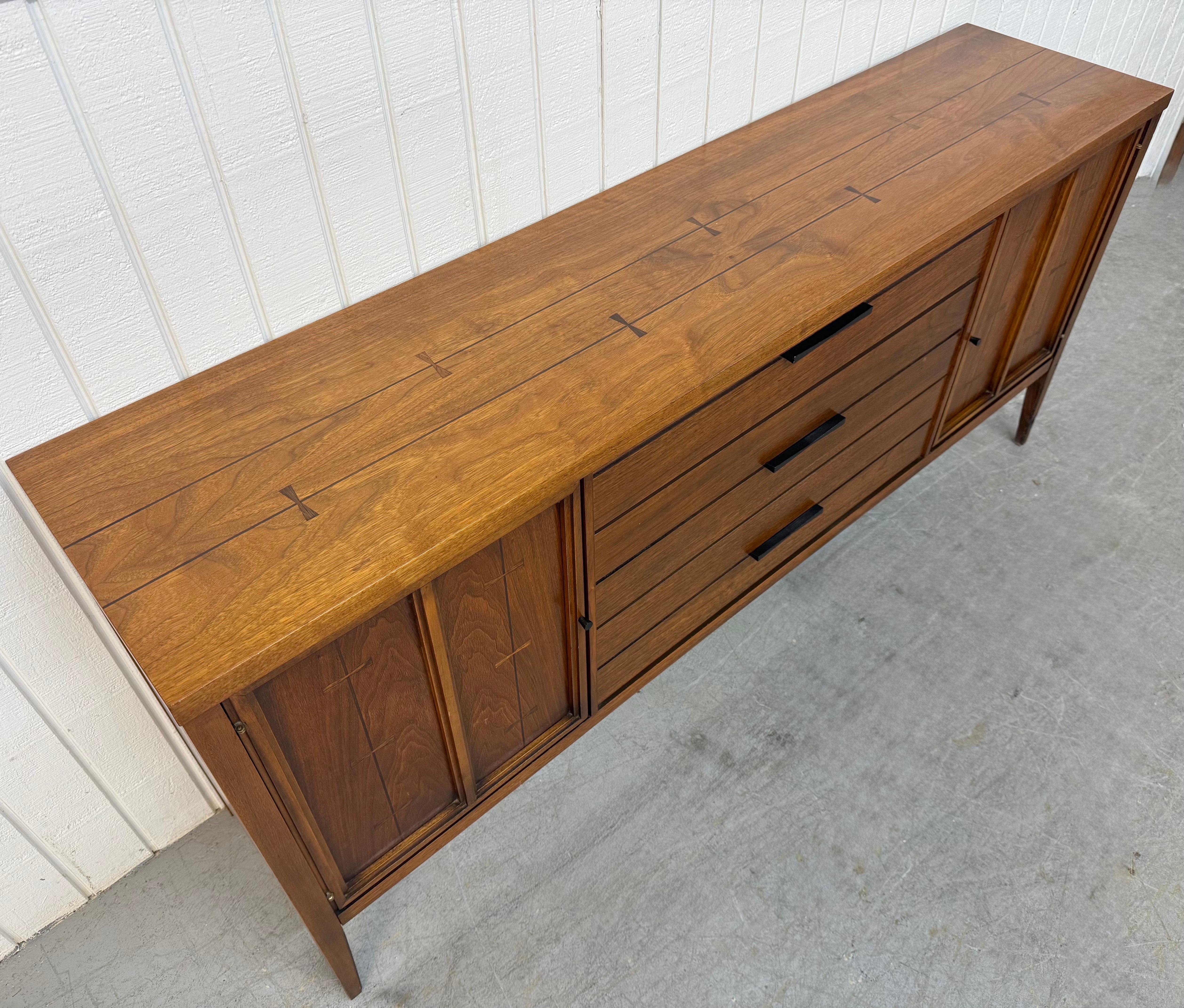This listing is for a Mid-Century Modern Lane Tuxedo Walnut Sideboard. Featuring a straight line design, two doors that open up to storage space, three center drawers with original black metal hardware, rosewood inlay, modern legs, and a beautiful