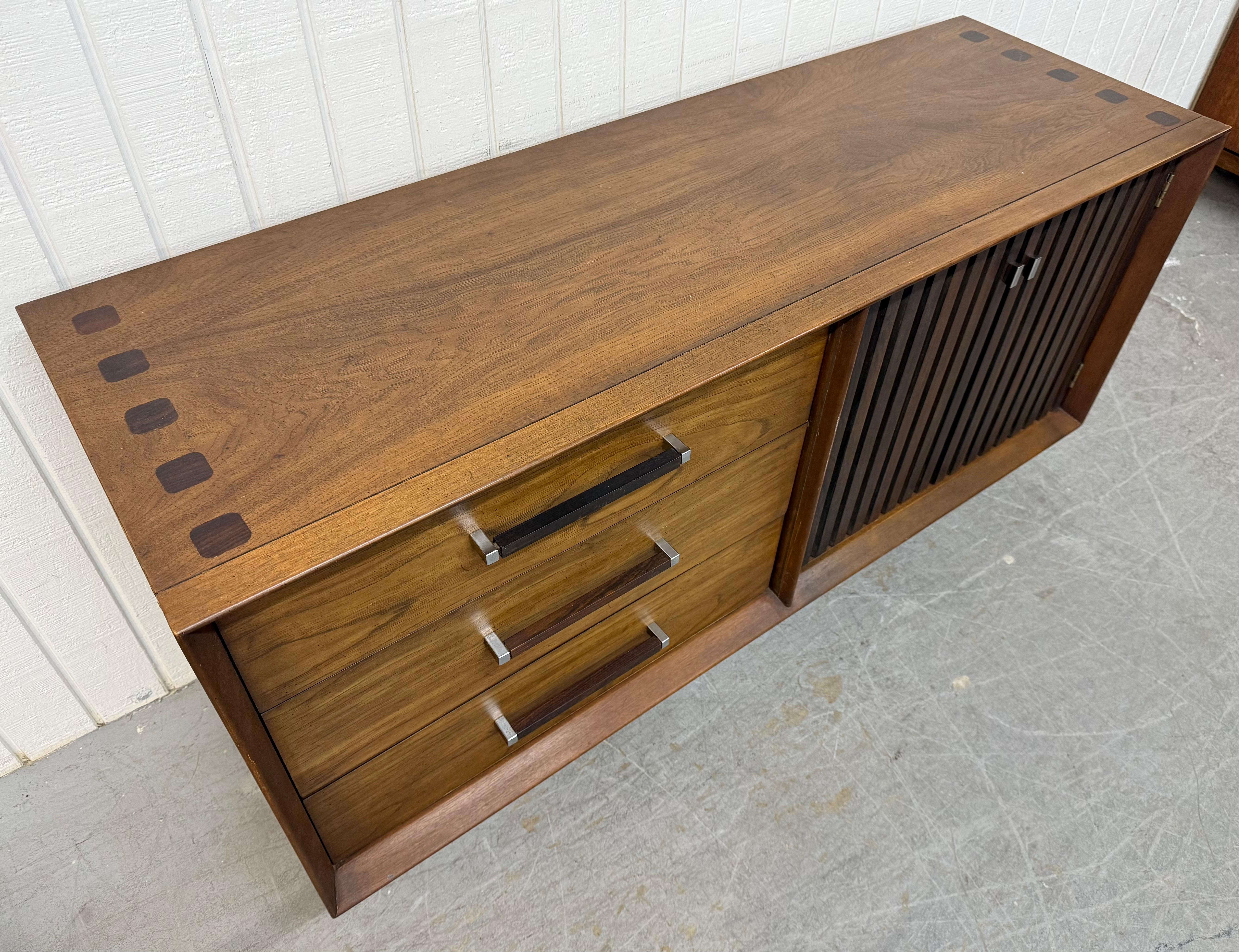 Questo annuncio si riferisce a una credenza in legno di noce e palissandro di Lane, in stile Mid-Century Modern. Caratterizzato da un design lineare, tre cassetti sul lato sinistro, tiretti originali in palissandro, ante a destra che si aprono per