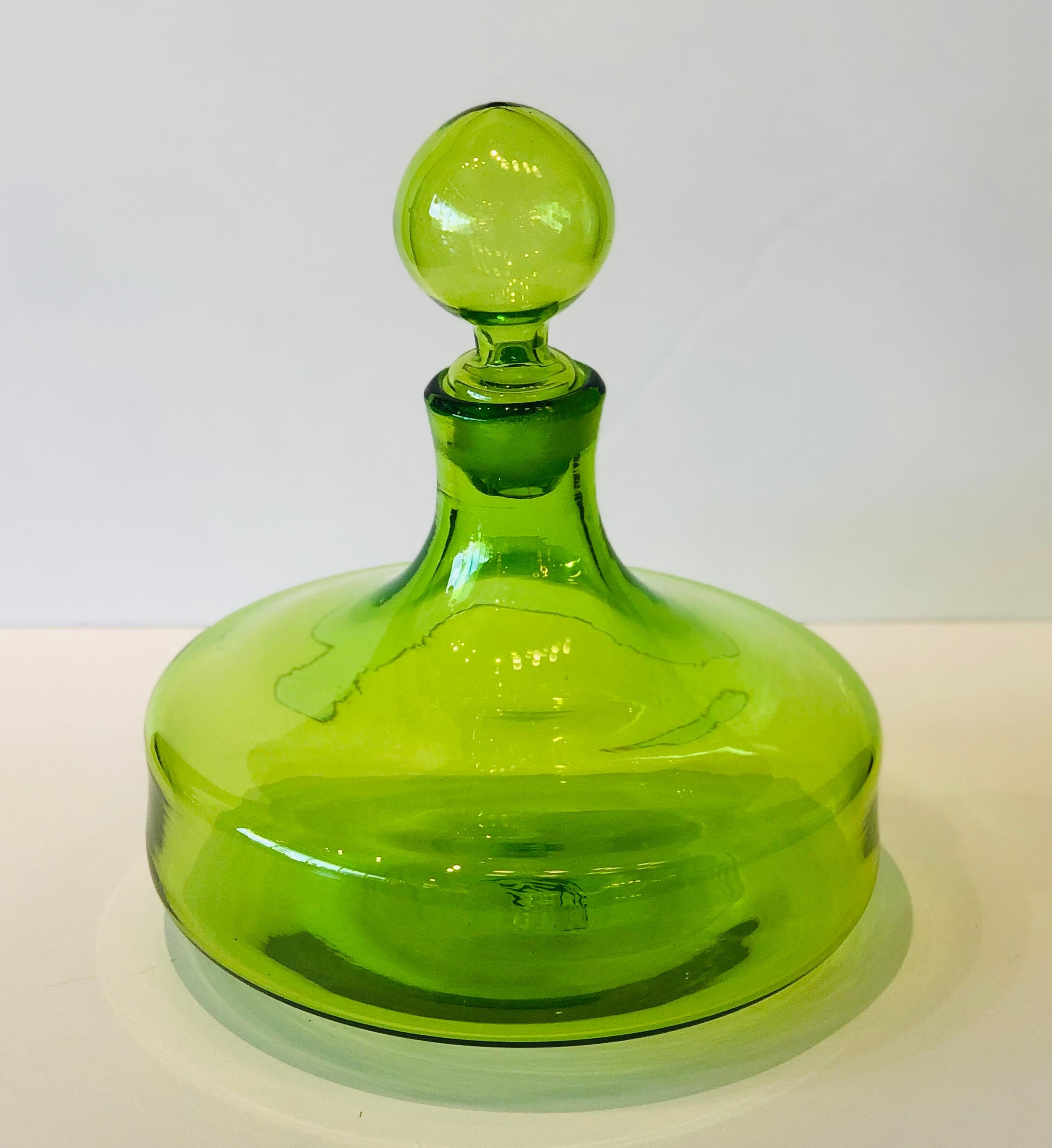 Offered is a Mid-Century Modern large chartreuse / apple green Blenko style blown glass decanter with large ball stopper. This special piece with its wonderful curves would look fabulous on a bar, bar cart, as a table centerpiece or as gorgeous