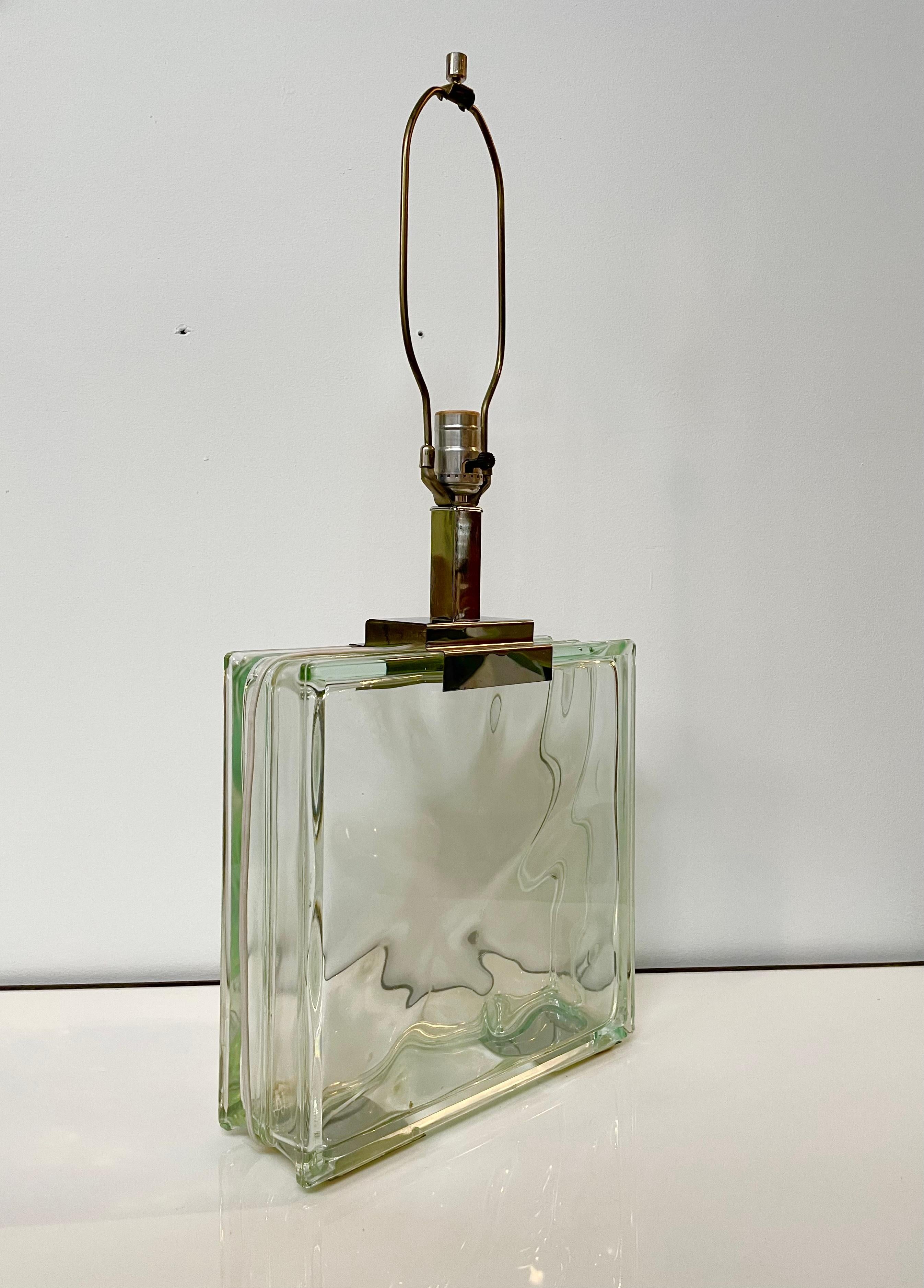 A nicely made table lamp produced by Raymor circa 1970's. It features a large glass block base with chrome details. Wiring is good and it's tested and working. Shade not included, just the lamp base.
